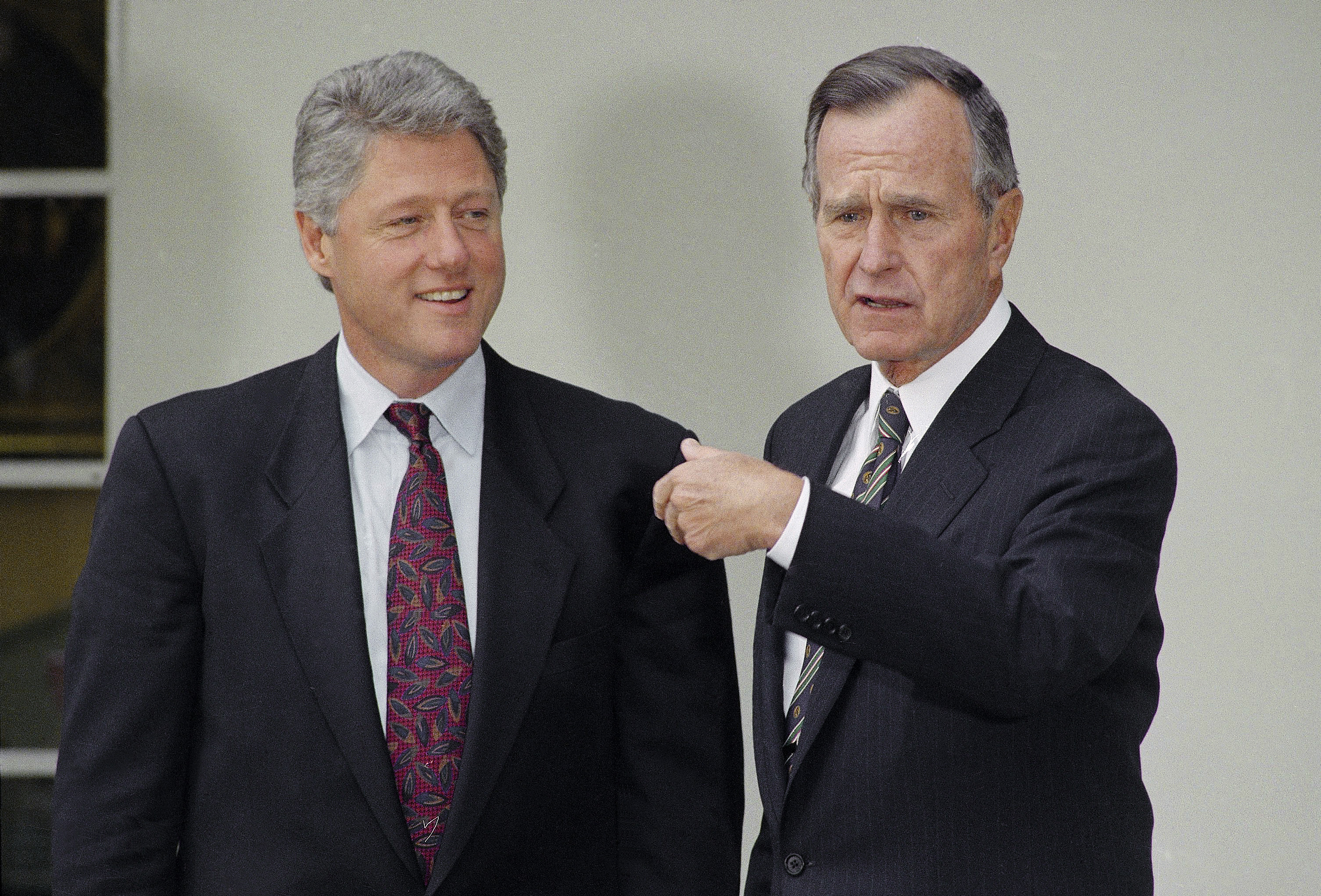 FILE - President George H.W. Bush gestures toward President-elect Bill Clinton at the White House, Nov. 18, 1992, in Washington. (AP Photo/Barry Thumma, File)