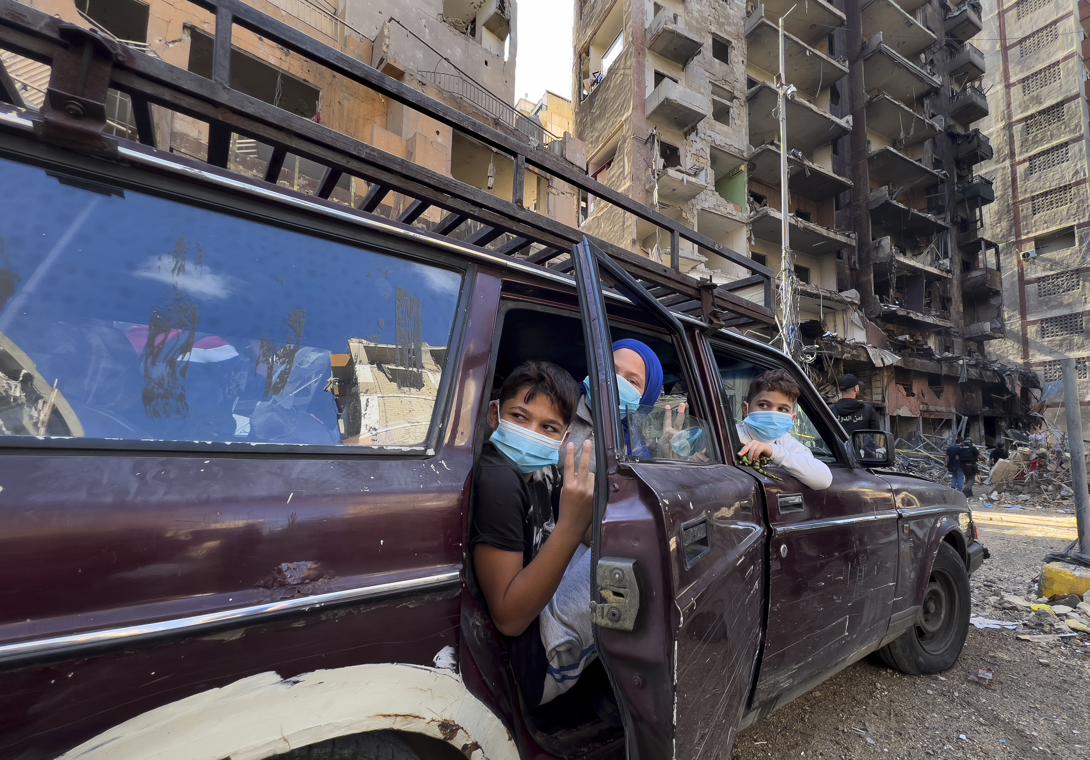 Children sit in a car as they wait their parents, who are collecting belongings from their house, which was destroyed by an Israeli airstrike in Dahiyeh, in the southern suburb of Beirut, Lebanon, Monday, Nov. 11, 2024. (AP Photo/Hussein Malla)