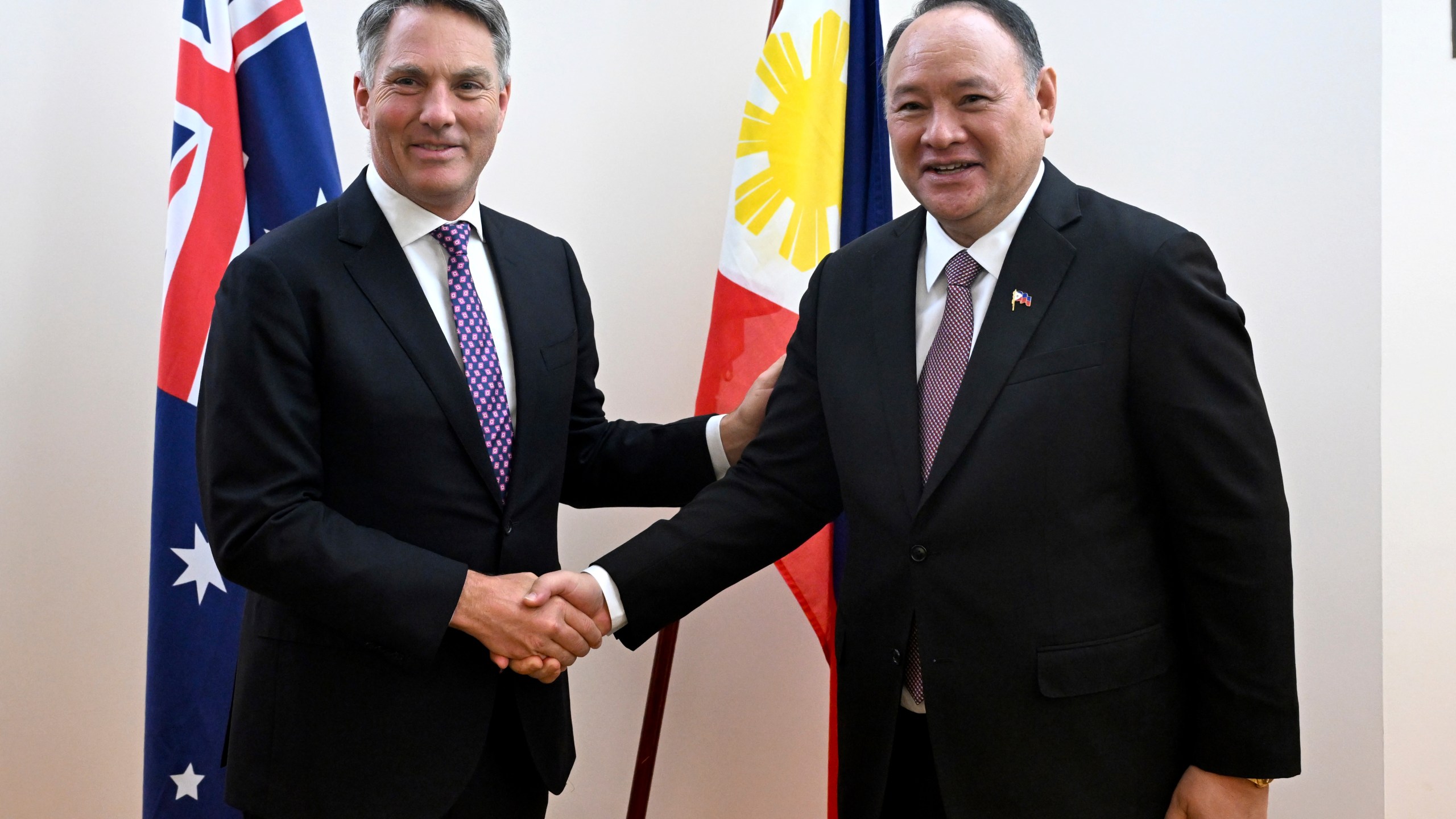 Australian Deputy Prime Minister Richard Marles, left, shakes hands with Philippine Secretary of National Defense Gilberto C. Teodoro Jr. during the inaugural Australia-Philippines Defence Ministers' Meeting at Parliament House in Canberra, Tuesday, Nov. 12, 2024. (Lukas Coch/AAP Image via AP)