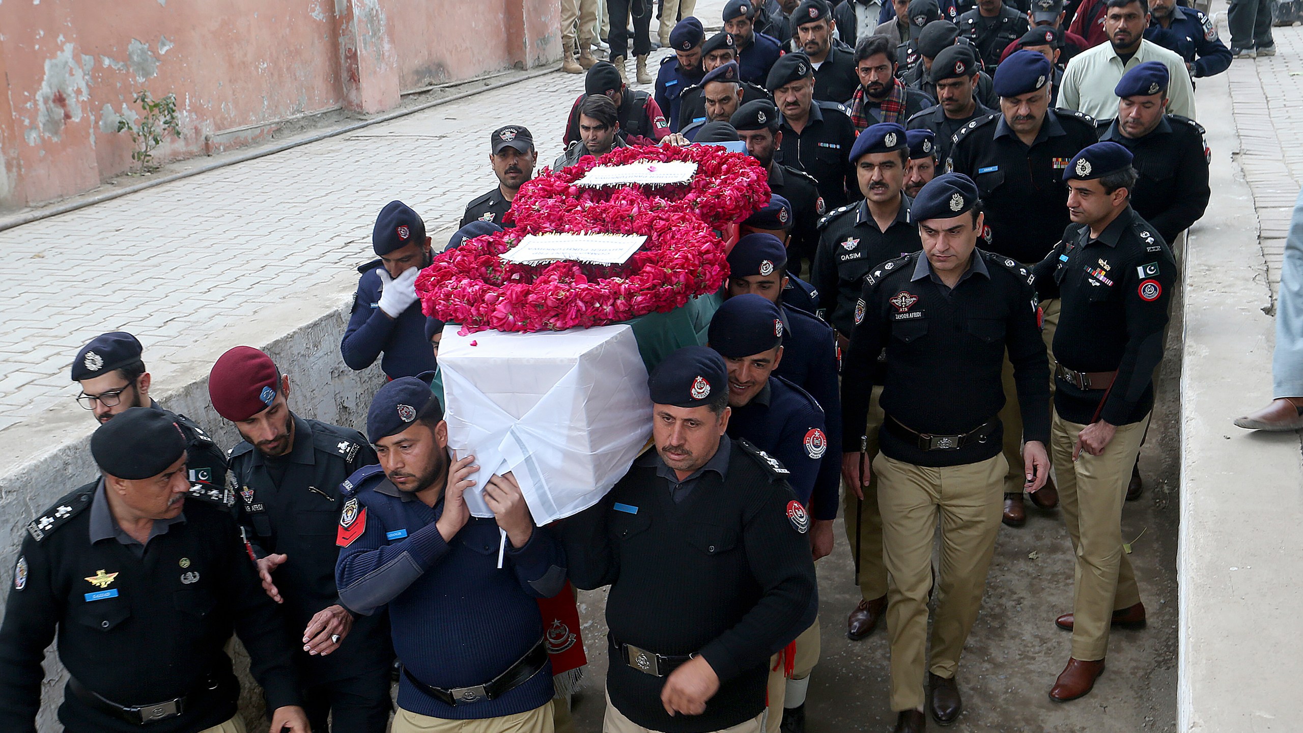 FILE - Police officers carry the casket of a fellow police officer, a victim of Monday's suicide bombing, for his funeral in Peshawar, Pakistan, Feb. 2, 2023. (AP Photo/Muhammad Sajjad, File)