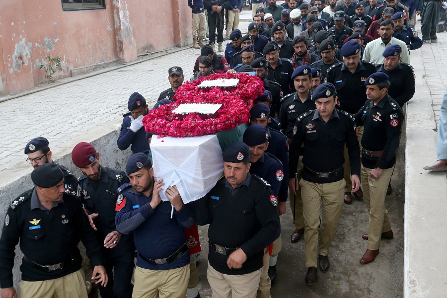 FILE - Police officers carry the casket of a fellow police officer, a victim of Monday's suicide bombing, for his funeral in Peshawar, Pakistan, Feb. 2, 2023. (AP Photo/Muhammad Sajjad, File)