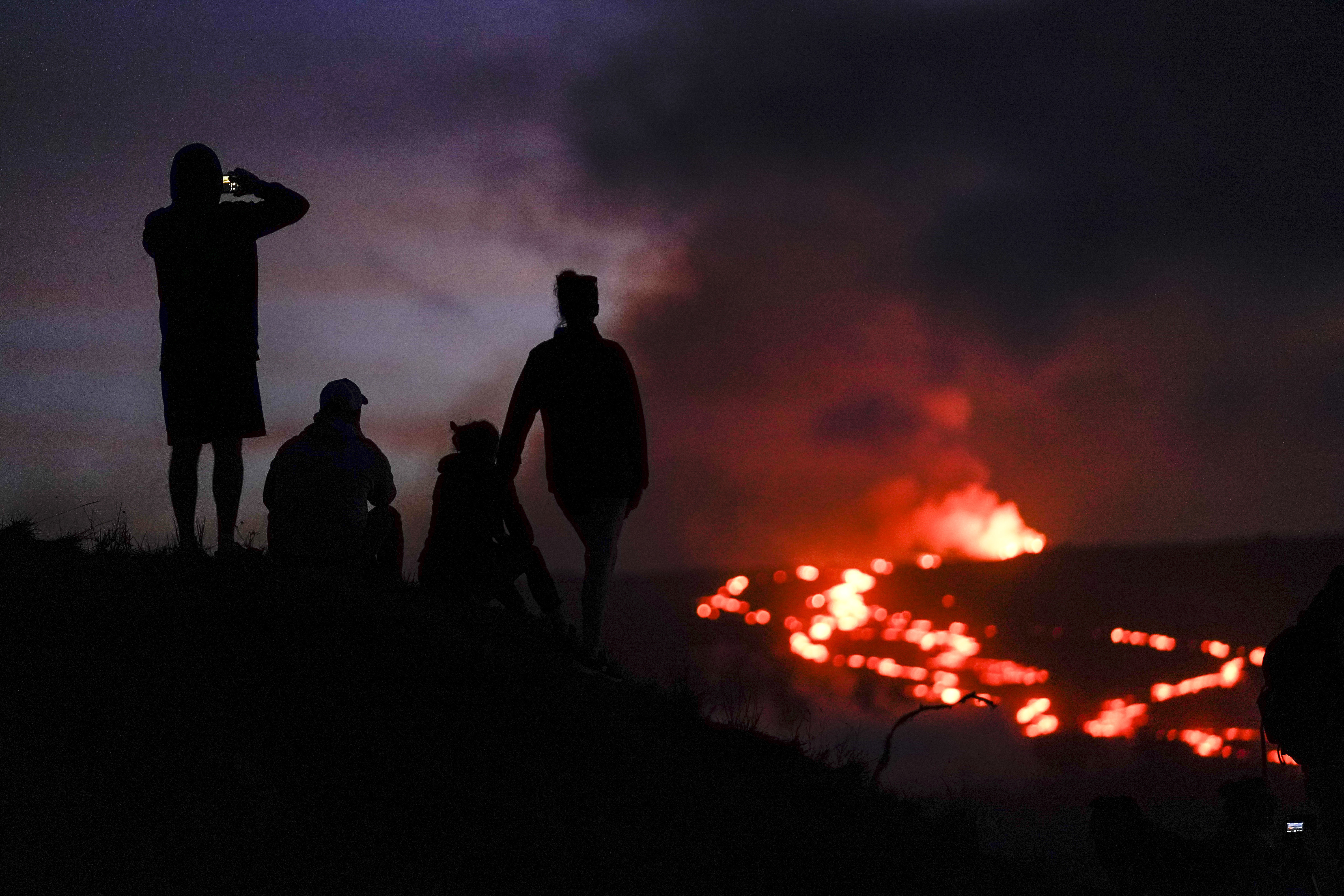 FILE - People watch lava from the Mauna Loa volcano Thursday, Dec. 1, 2022, near Hilo, Hawaii. (AP Photo/Gregory Bull, File)