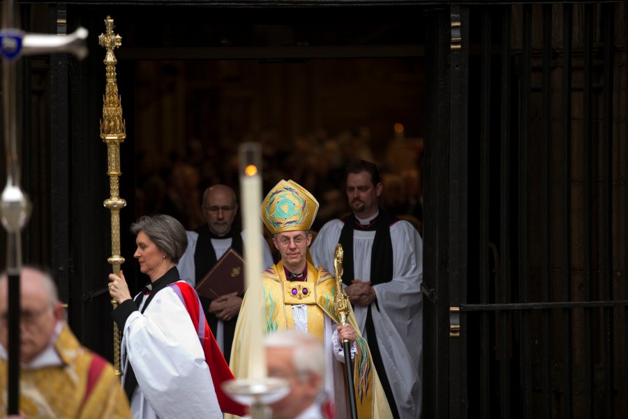 FILE - Britain's new Archbishop of Canterbury Justin Welby, center, leaves after his enthronement ceremony at Canterbury Cathedral in Canterbury, England, Thursday, March 21, 2013. (AP Photo/Matt Dunham, File)