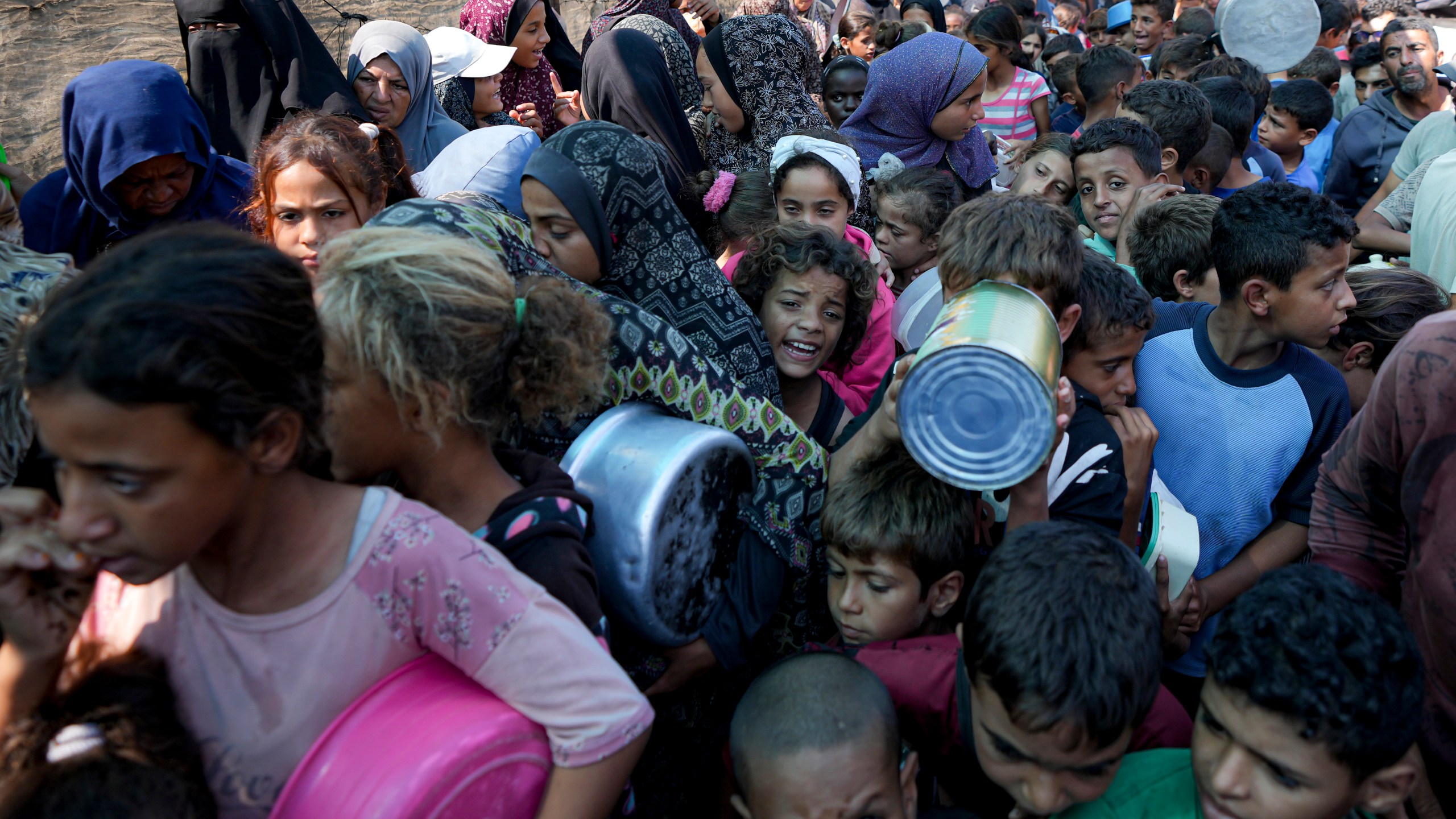 FILE - Palestinians line up for food distribution in Deir al-Balah, Gaza Strip, on Oct. 17, 2024. (AP Photo/Abdel Kareem Hana, File)