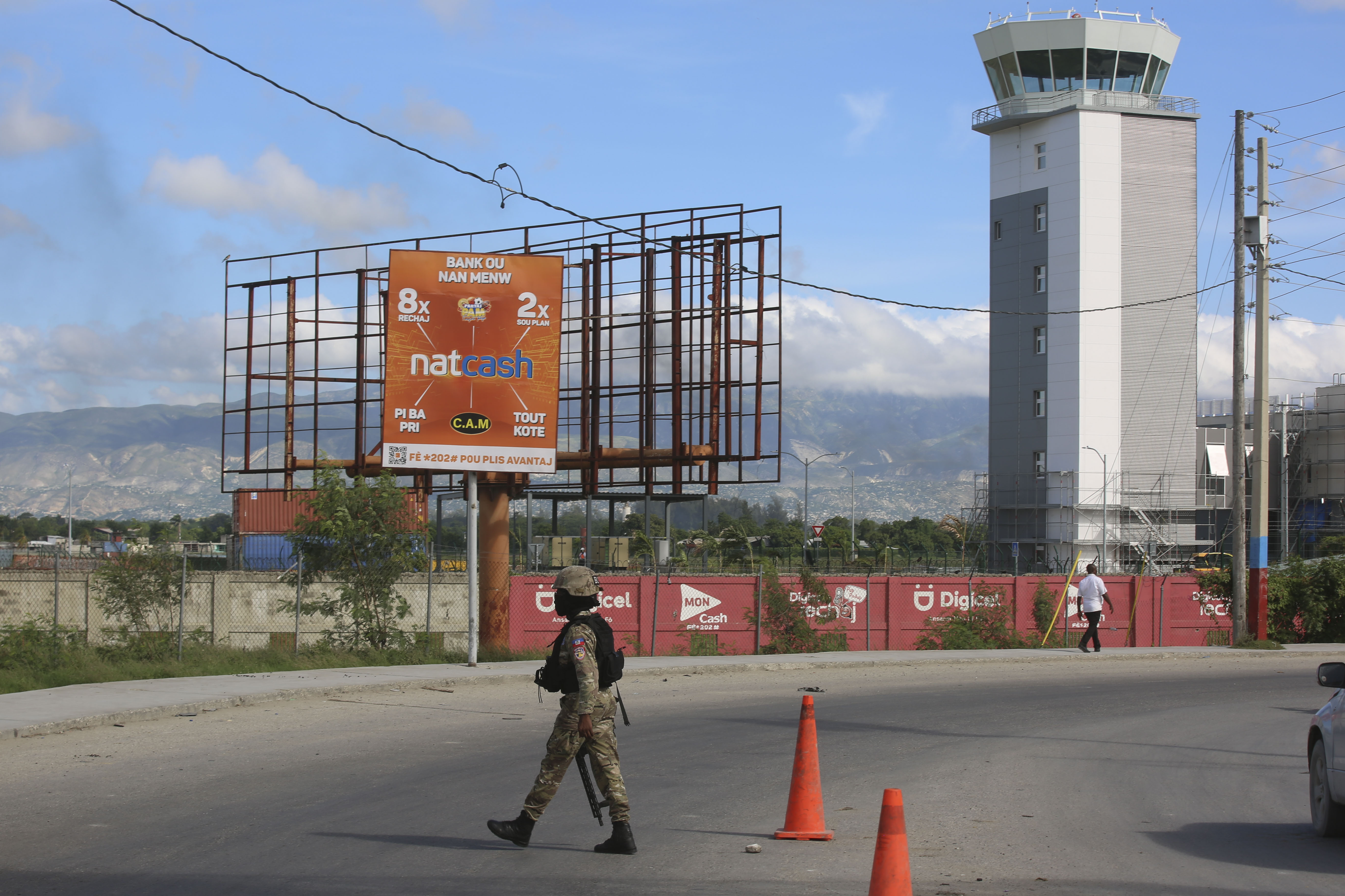 A police officer patrols the entrance of the Toussaint Louverture International Airport, in Port-au-Prince, Haiti, Tuesday, Nov. 12, 2024. (AP Photo/Odelyn Joseph)