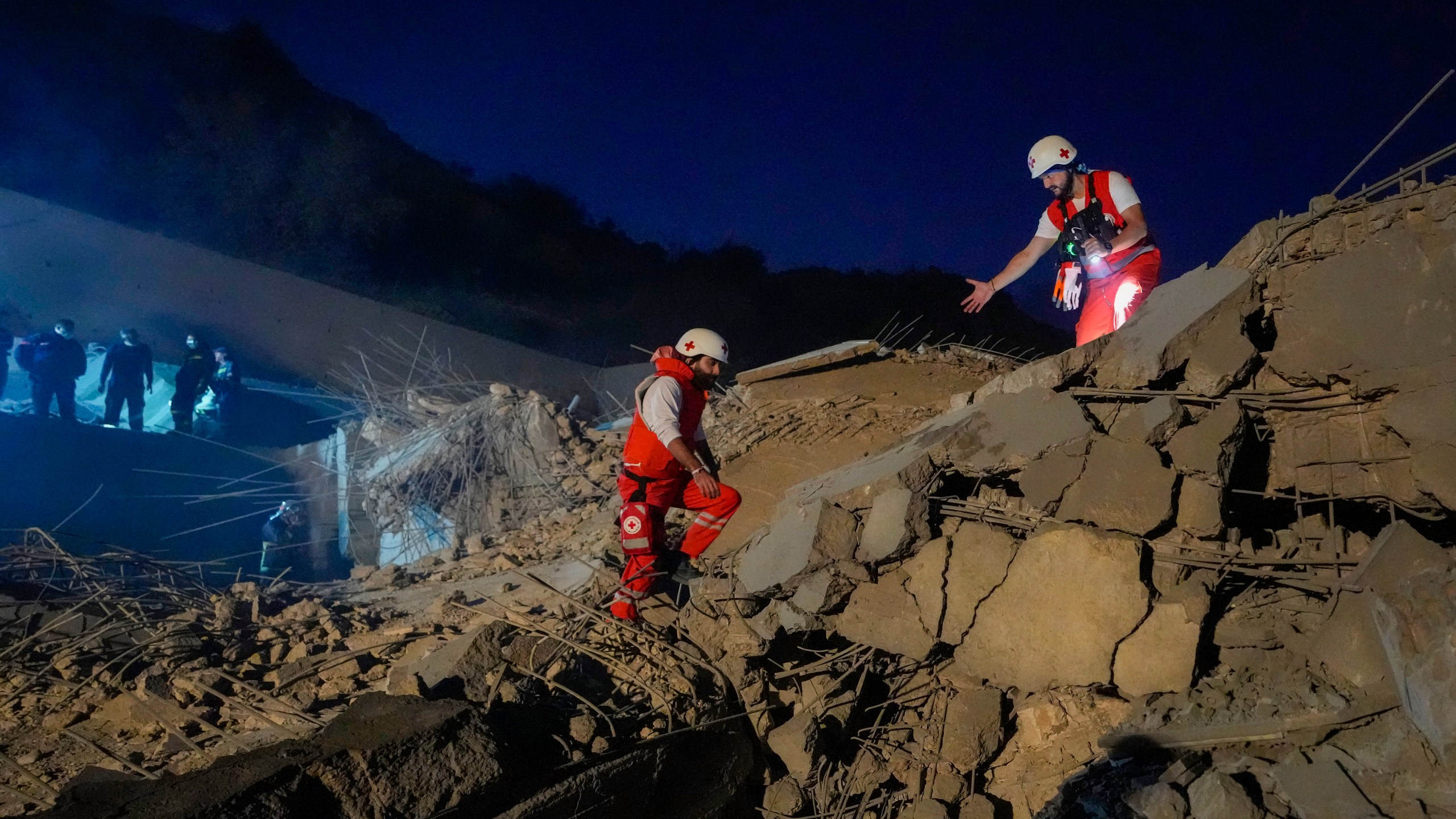 Lebanese Red Cross volunteers and other rescuers search for victims at a house that was hit in an Israeli airstrike in Baalchmay village east of Beirut, Lebanon, Tuesday, Nov. 12, 2024. (AP Photo/Hassan Ammar)