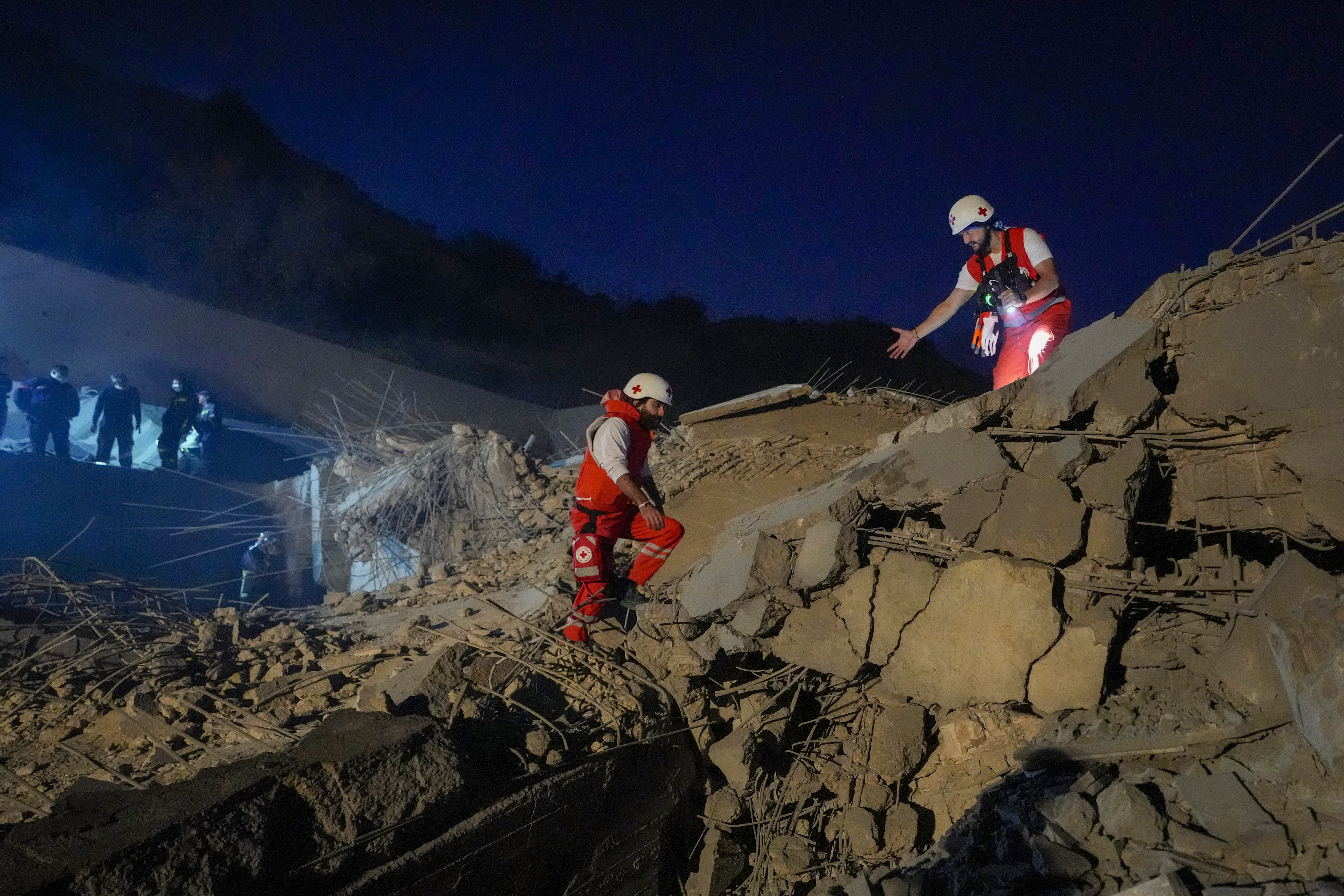 Lebanese Red Cross volunteers and other rescuers search for victims at a house that was hit in an Israeli airstrike in Baalchmay village east of Beirut, Lebanon, Tuesday, Nov. 12, 2024. (AP Photo/Hassan Ammar)