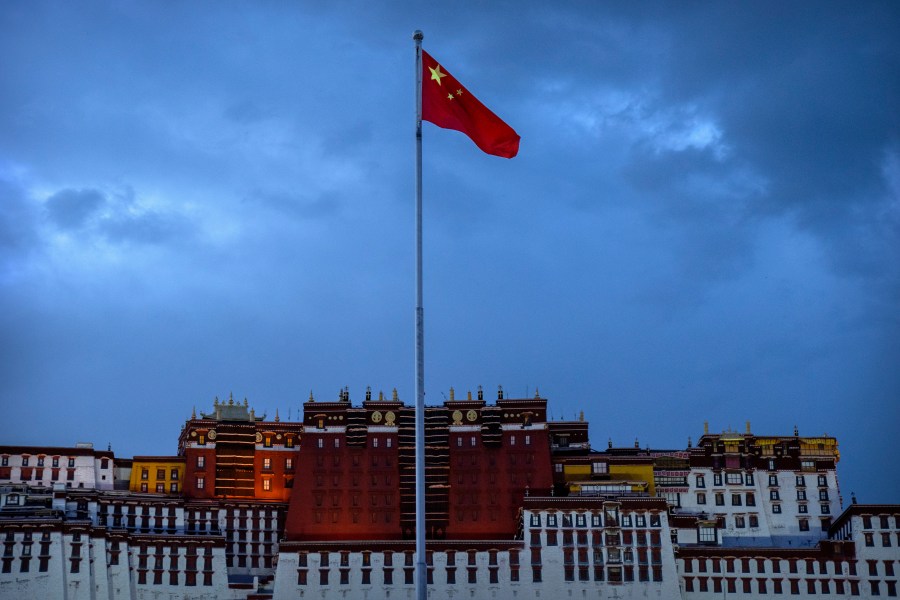 FILE- The Chinese flag flies at a plaza near the Potala Palace in Lhasa in western China's Tibet Autonomous Region, June 1, 2021, as seen during a government organized visit for foreign journalists. (AP Photo/Mark Schiefelbein, File)