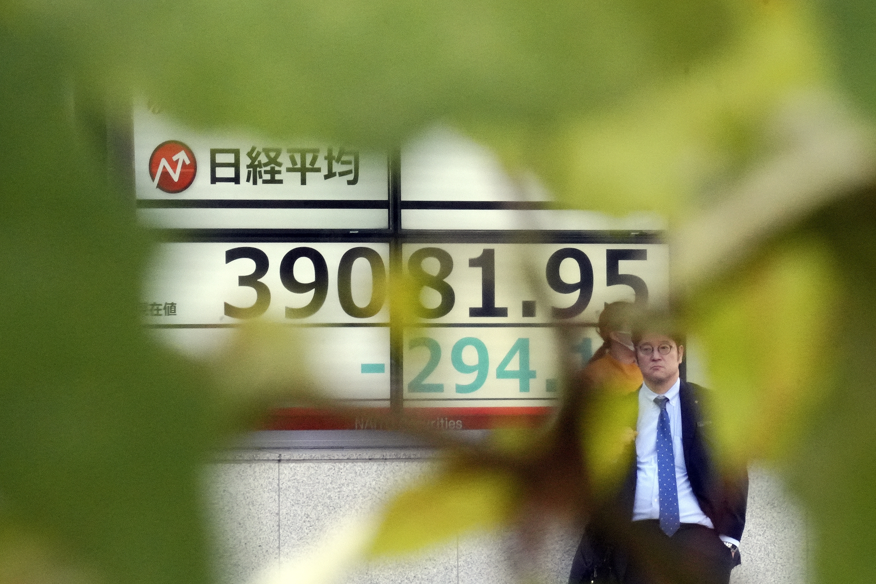 A person stands in front of an electronic stock board showing Japan's Nikkei index at a securities firm Wednesday, Nov. 13, 2024, in Tokyo. (AP Photo/Eugene Hoshiko)