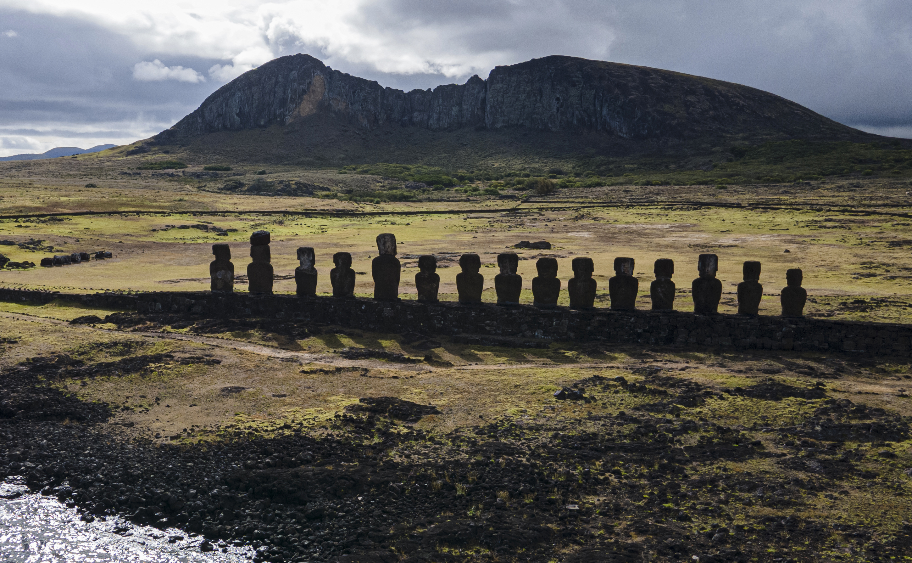 FILE - Moai statues stand on Ahu Tongariki near the Rano Raraku volcano, top, on Rapa Nui, or Easter Island, Chile, Nov. 27, 2022. (AP Photo/Esteban Felix, File)