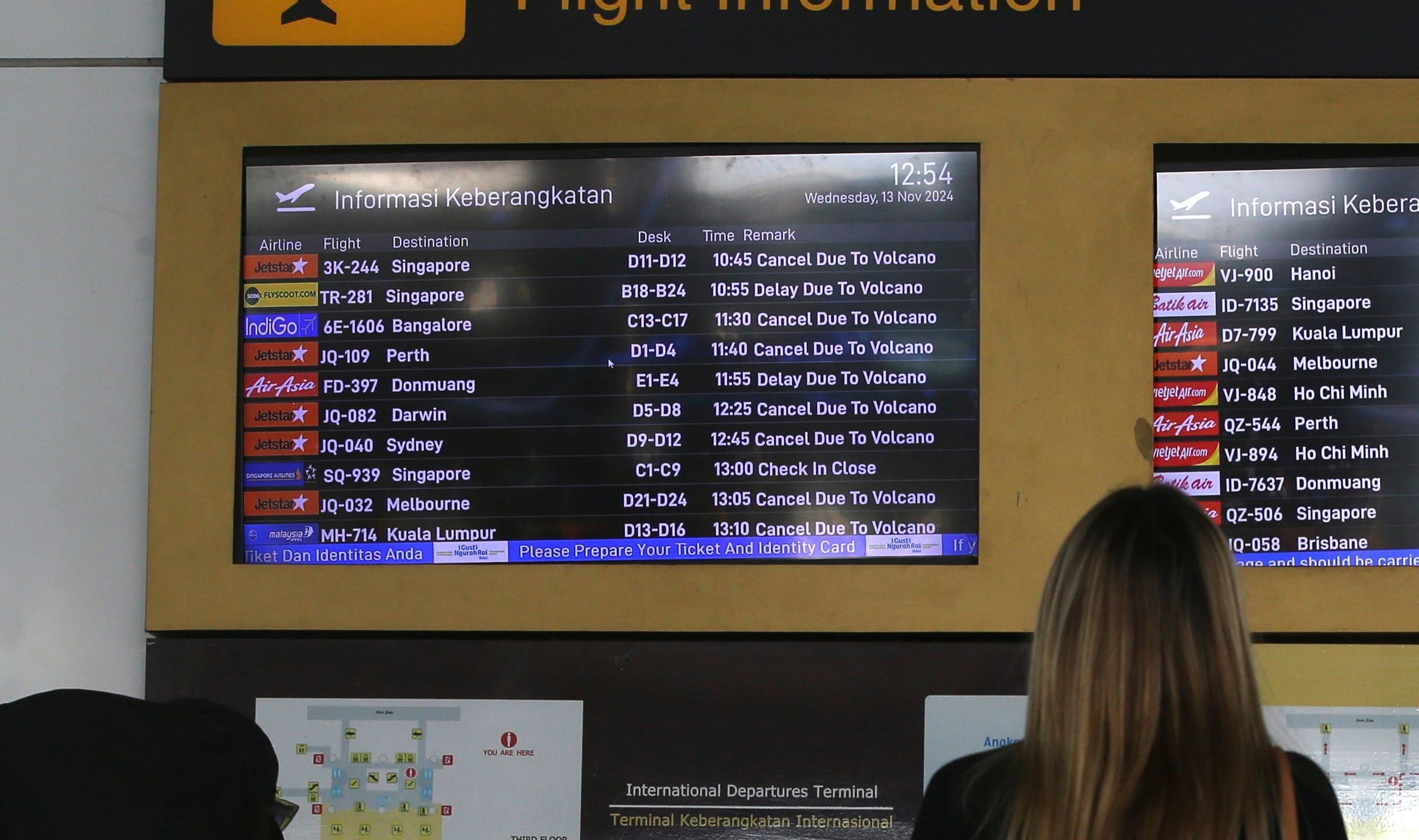 A passenger checks a flight information board showing flights cancelled due to the eruption of Mount Lewotobi Laki-Laki, at Ngurah Rai International Airport in Bali, Indonesia, Wednesday, Nov. 13, 2024. (AP Photo/Firdia Lisnawati)