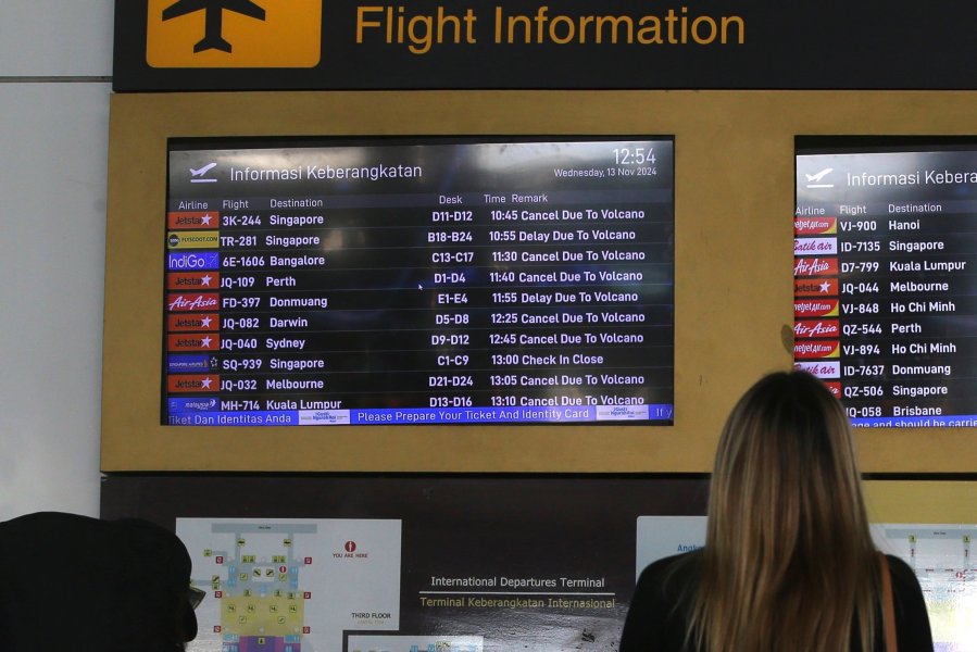 A passenger checks a flight information board showing flights cancelled due to the eruption of Mount Lewotobi Laki-Laki, at Ngurah Rai International Airport in Bali, Indonesia, Wednesday, Nov. 13, 2024. (AP Photo/Firdia Lisnawati)