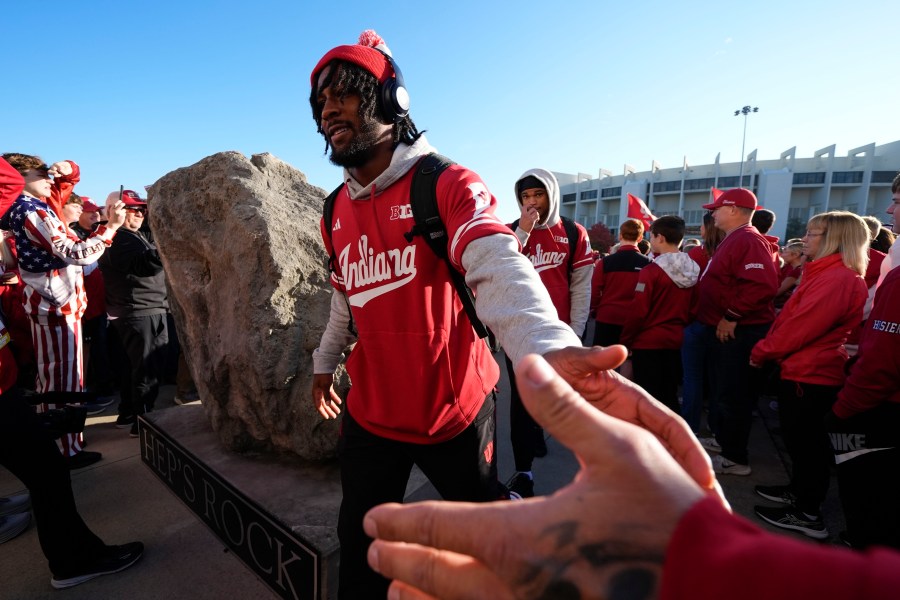 Indiana football players touch "Hep's Rock" and they enter Memorial Stadium before an NCAA college football game against the Washington, Saturday, Oct. 26, 2024, in Bloomington, Ind. (AP Photo/Darron Cummings)