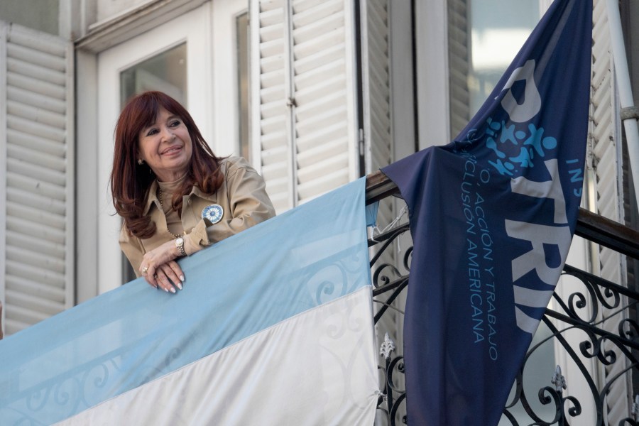 Former President Cristina Fernández smiles at supporters who have rallied outside her residence after a tribunal upheld a six-year sentence term and lifetime ban from holding public office sentence against Fernández, in Buenos Aires, Argentina, Wednesday, Nov. 13, 2024. (AP Photo/Victor R. Caivano)