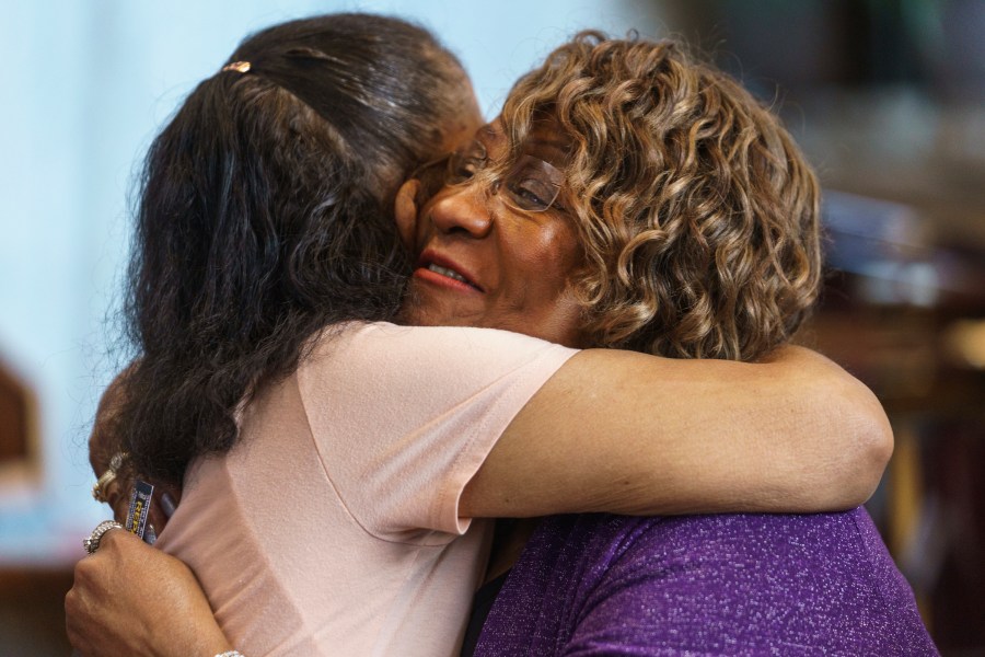 FILE - Pearl Taylor Devers the chairperson for the Palm Springs Section 14 Survivors group, right, is hugged by another member at the United Methodist Church in Palm Springs, Calif., Sunday, April 16, 2023. (AP Photo/Damian Dovarganes, File)