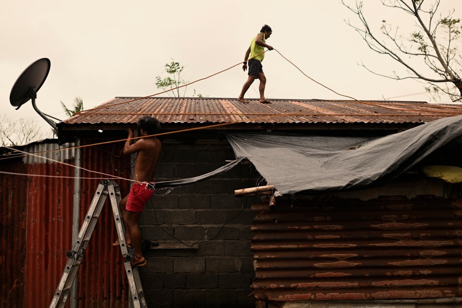 A resident reinforces his roof in Santa Ana, Cagayan Province, northern Philippines as they anticipate Typhoon Usagi to hit their area Thursday, Nov. 14, 2024. (AP Photo/Noel Celis)