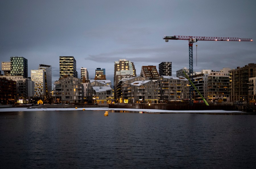 FILE - The sun reflected in the windows of the skyline of the so called 'Barcode Project' neighborhood at dusk in Oslo, Norway, on Dec. 8, 2022. (AP Photo/Markus Schreiber, File)