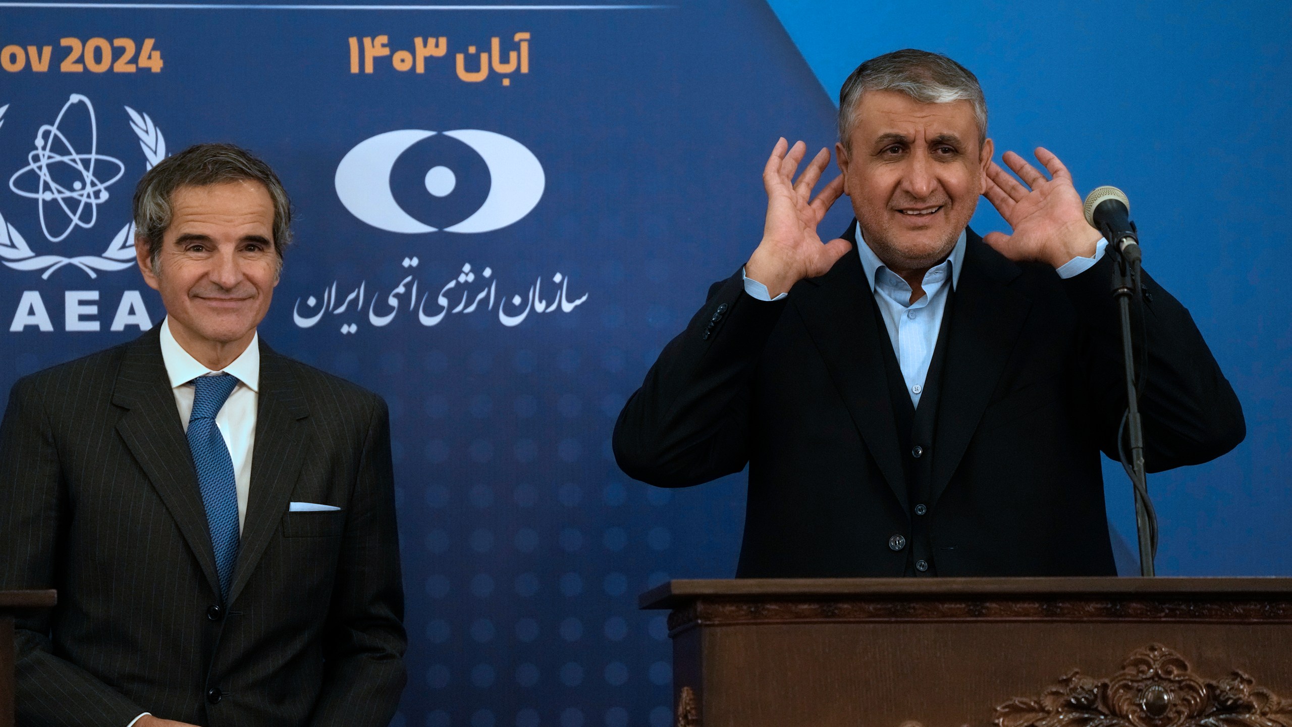 Head of Atomic Energy Organization of Iran Mohammad Eslami, right, tries to listen to a journalist at the conclusion of his joint press conference with International Atomic Energy Agency (IAEA) Director General Rafael Mariano Grossi in Tehran, Iran, Thursday, Nov. 14, 2024. (AP Photo/Vahid Salemi)