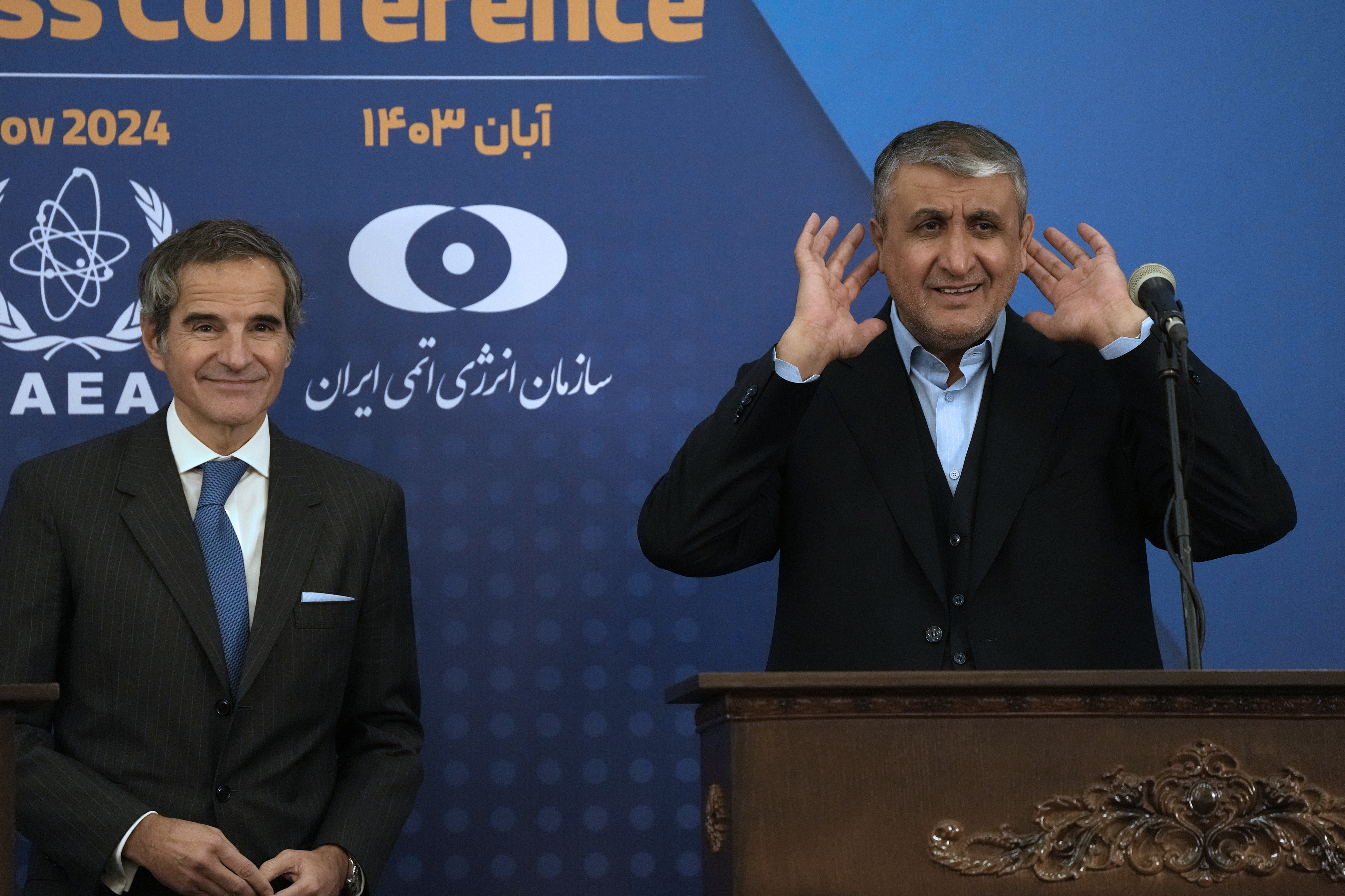 Head of Atomic Energy Organization of Iran Mohammad Eslami, right, tries to listen to a journalist at the conclusion of his joint press conference with International Atomic Energy Agency (IAEA) Director General Rafael Mariano Grossi in Tehran, Iran, Thursday, Nov. 14, 2024. (AP Photo/Vahid Salemi)