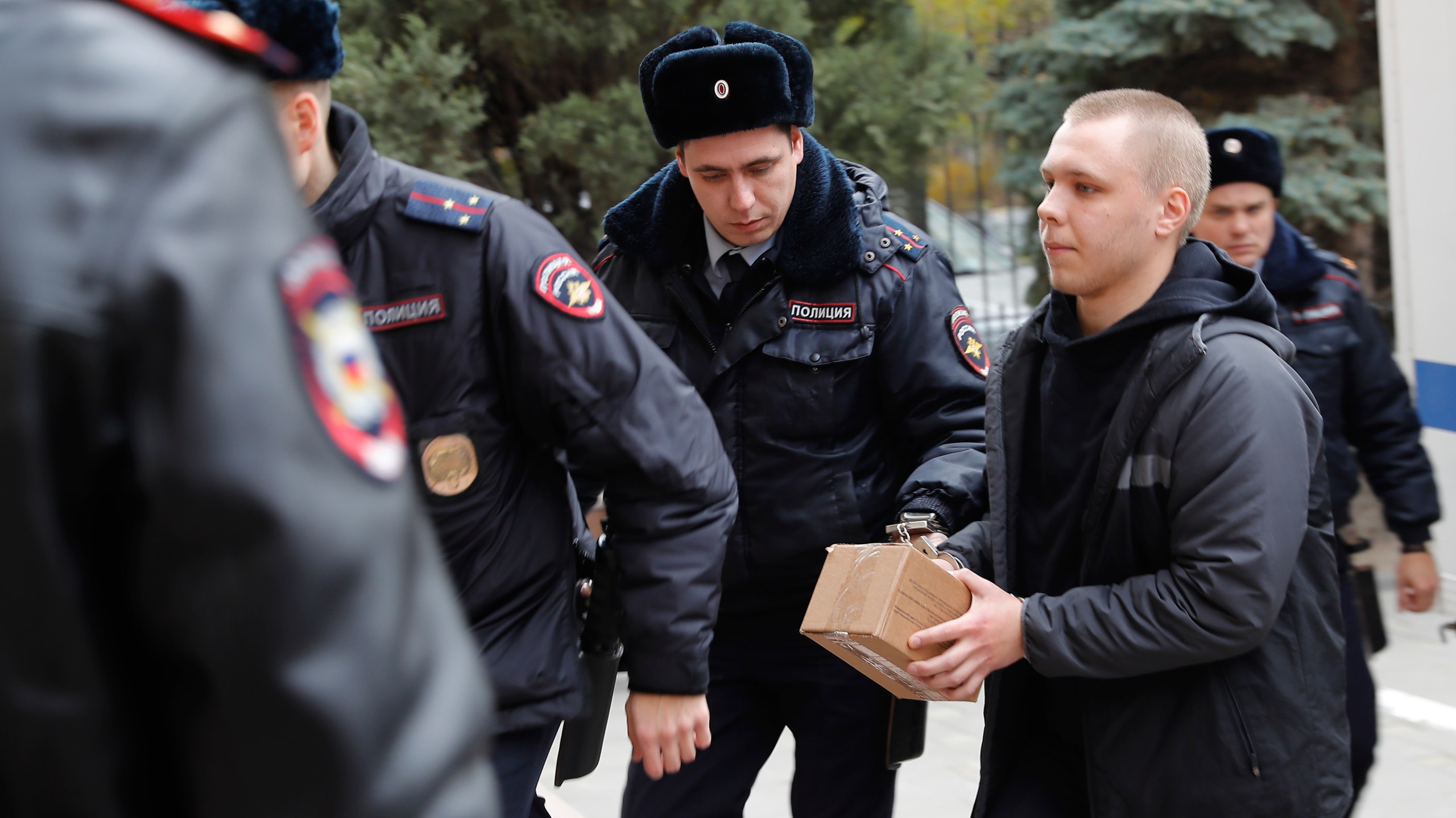 Nikita Zhuravel, right, is escorted by the police to a court prior to a hearing of a treason case in Volgograd, Russia, Thursday, Nov. 14, 2024. (AP Photo)