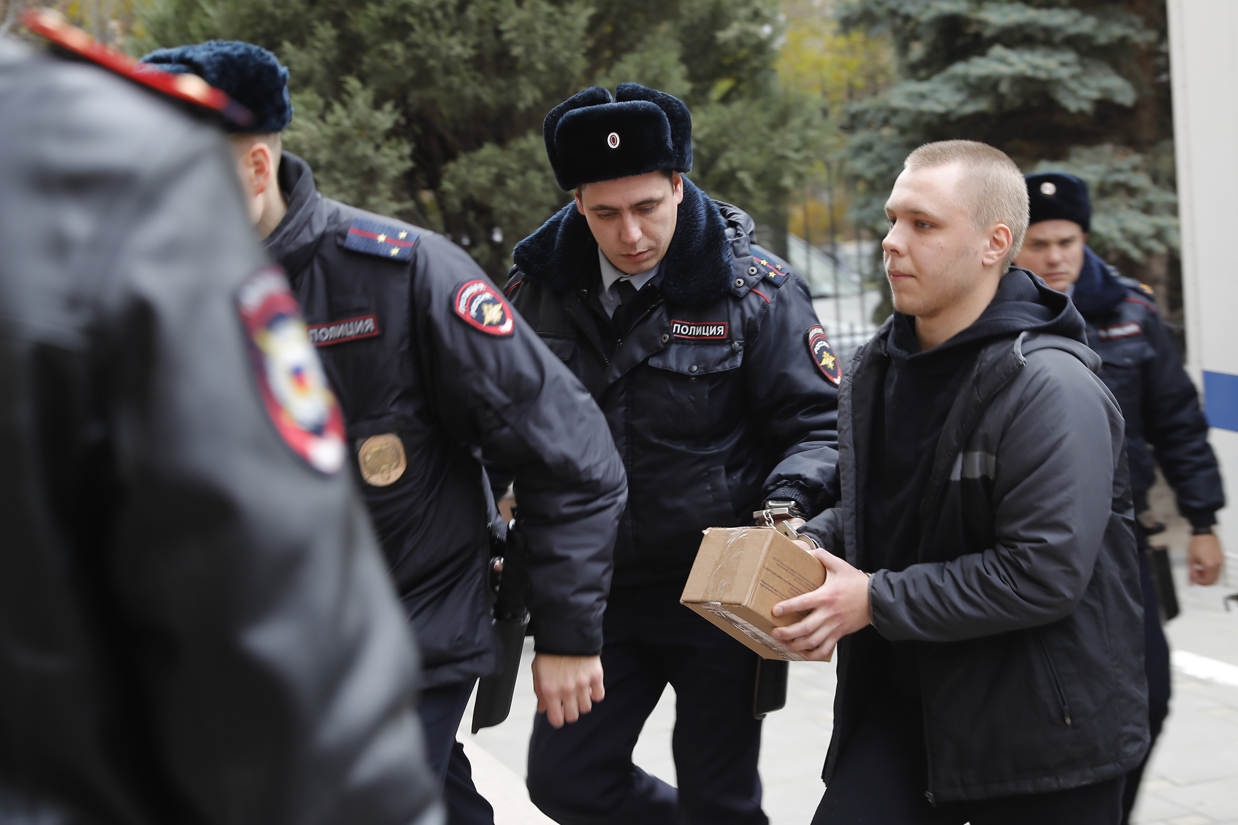 Nikita Zhuravel, right, is escorted by the police to a court prior to a hearing of a treason case in Volgograd, Russia, Thursday, Nov. 14, 2024. (AP Photo)