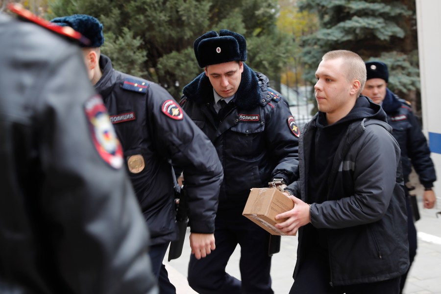 Nikita Zhuravel, right, is escorted by the police to a court prior to a hearing of a treason case in Volgograd, Russia, Thursday, Nov. 14, 2024. (AP Photo)