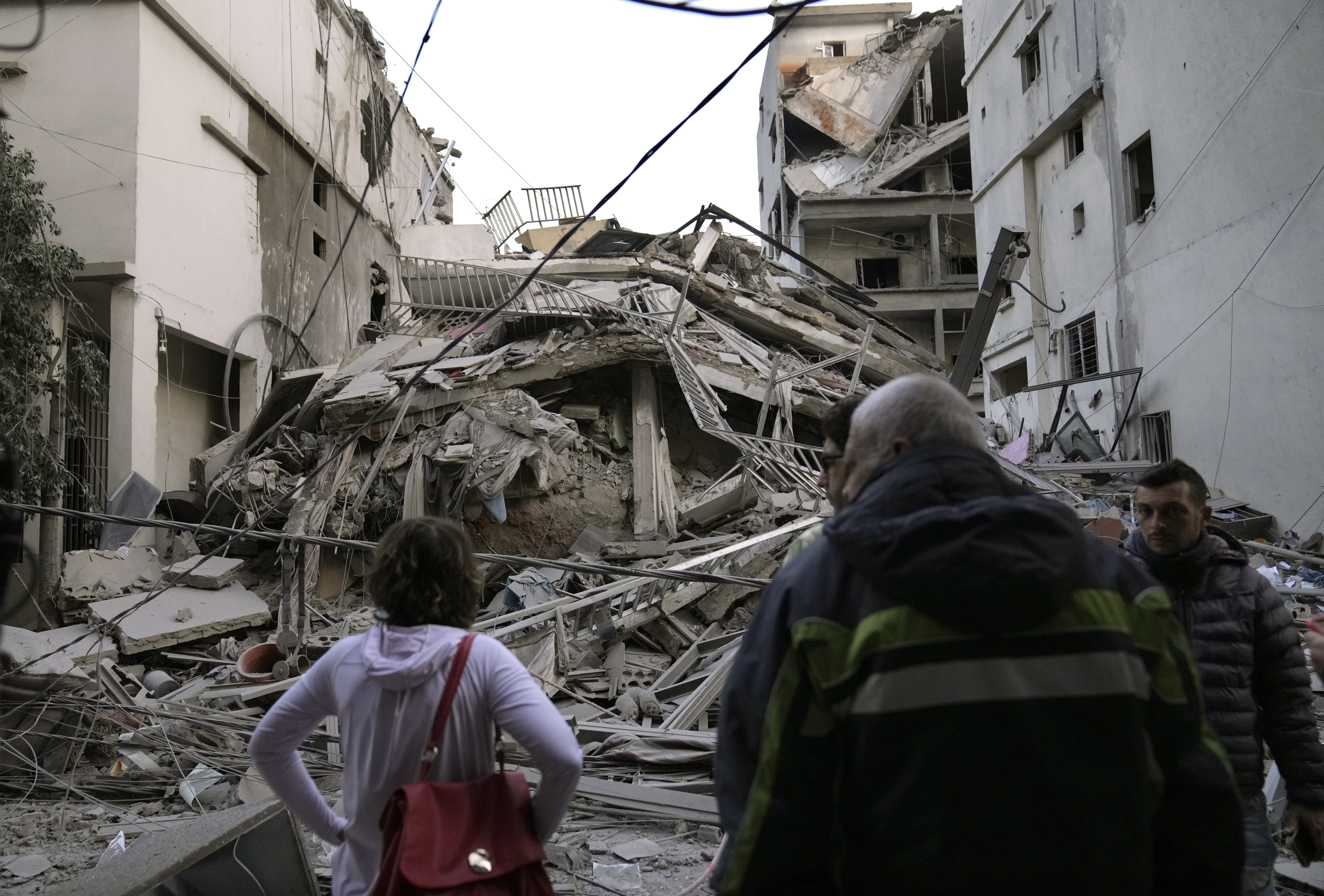 Residents check their destroyed building hit in an Israeli airstrike in Dahiyeh, in the southern suburb of Beirut, Lebanon, Thursday, Nov. 14, 2024. (AP Photo/Hussein Malla)