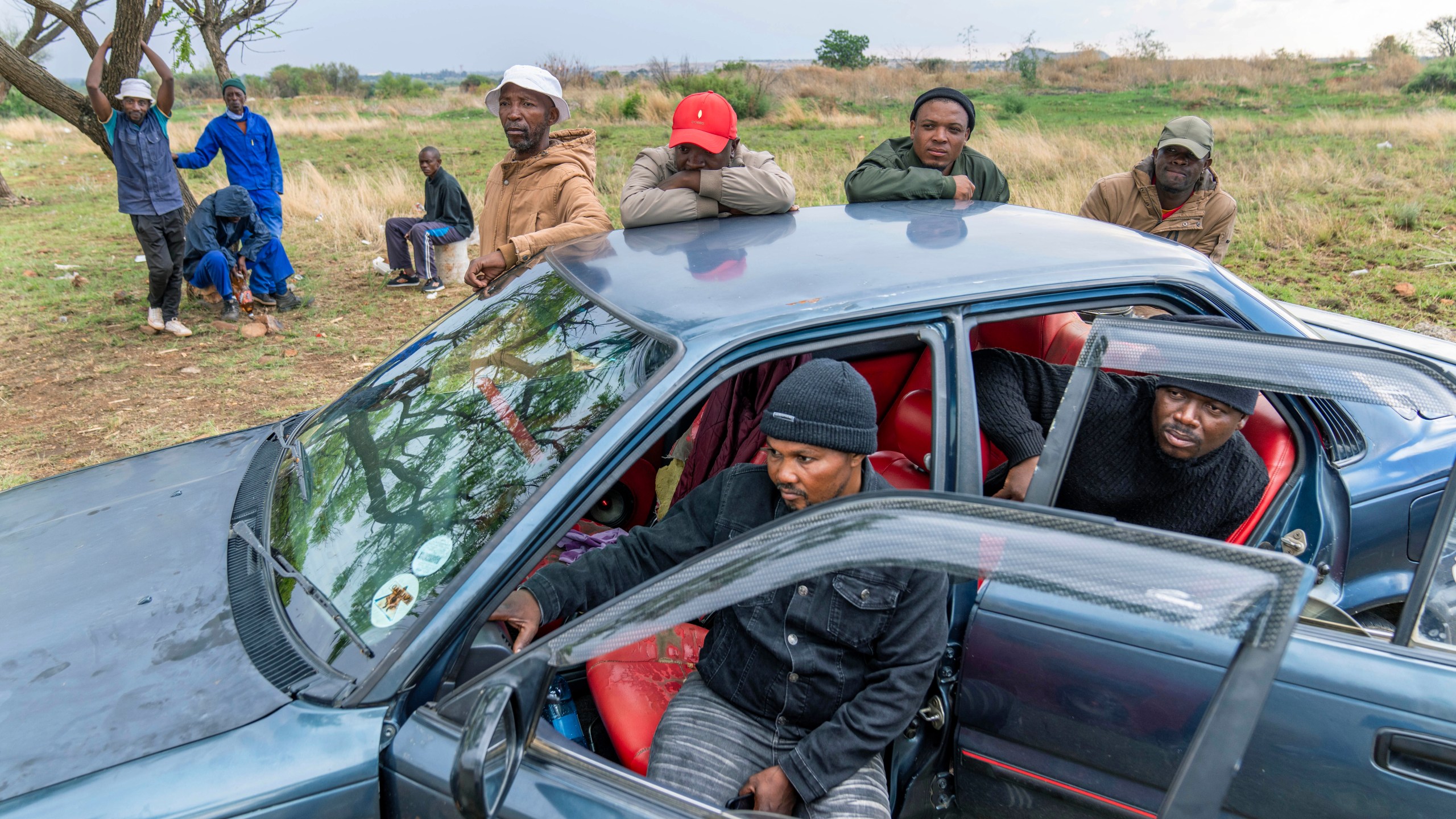 Relatives of miners and community members wait at a mine shaft where illegal miners are trapped in a disused mine in Stilfontein, South Africa, Thursday, Nov.14, 2024. (AP Photo/Jerome Delay)