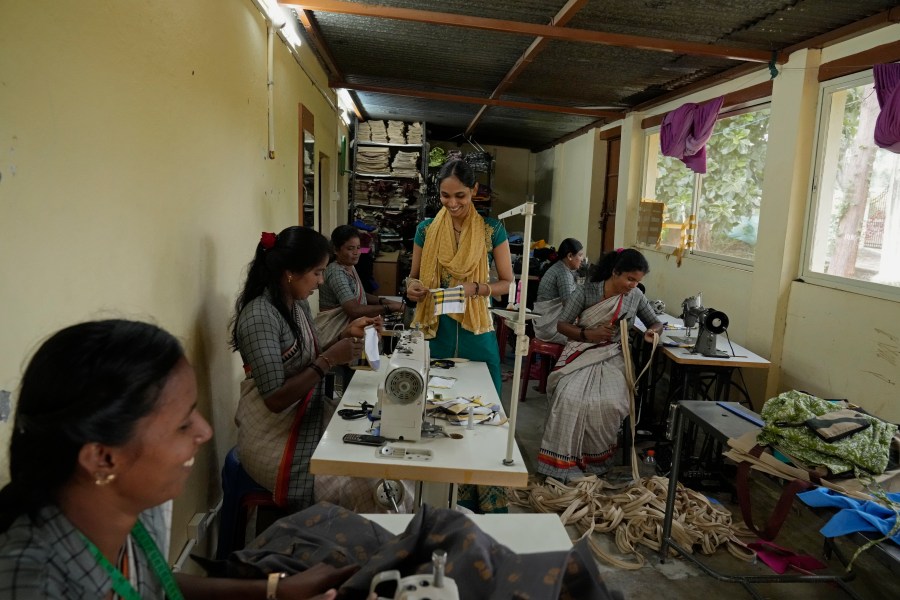 A group of tailors work in a small garage using electric sewing machines to stitch office uniforms and bags at the campus of the Swami Vivekananda Youth Movement, a nongovernmental organization that works to help poor and Indigenous communities, in Kenchanahalli, India, Monday, Sept. 23, 2024. (AP Photo/Aijaz Rahi)