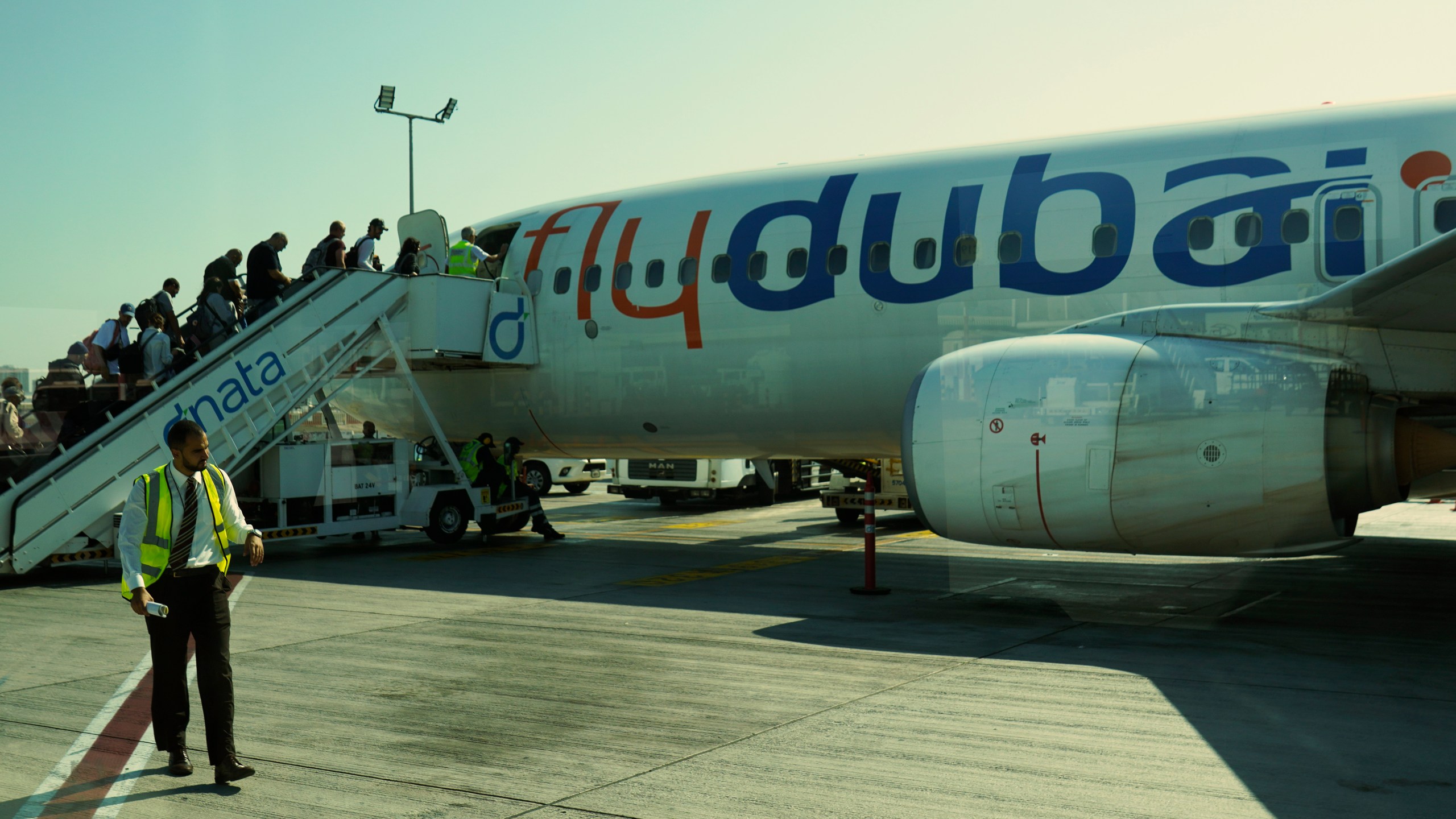 Passengers for a FlyDubai flight heading to Ben Gurion International Airport in Israel board their aircraft at Dubai International Airport in Dubai, United Arab Emirates, Friday, Oct. 18, 2024. (AP Photo/Jon Gambrell)