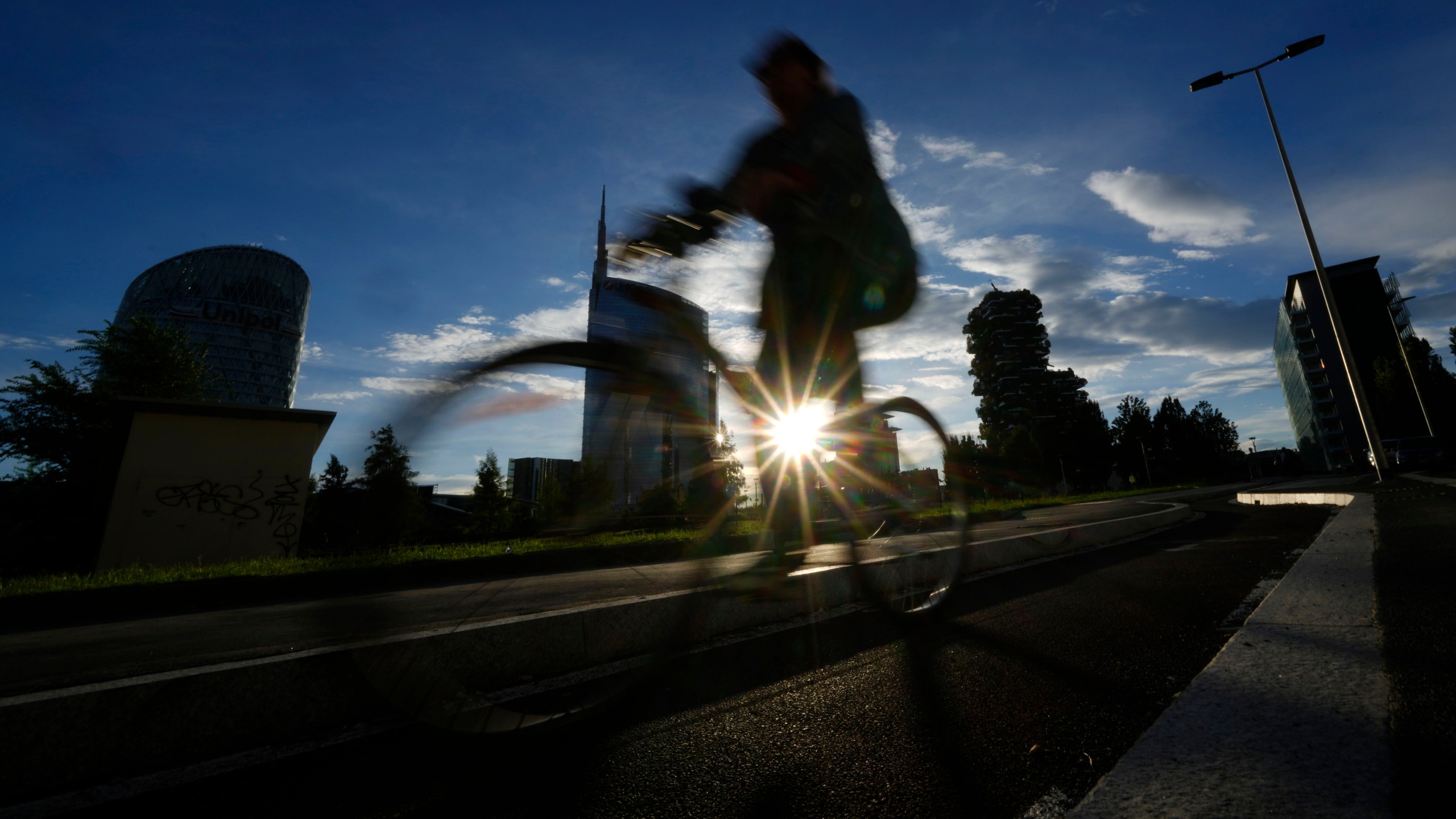 A man bikes as the sun sets in Milan, Italy, Friday, Sept. 13, 2024. (AP Photo/Luca Bruno, file)