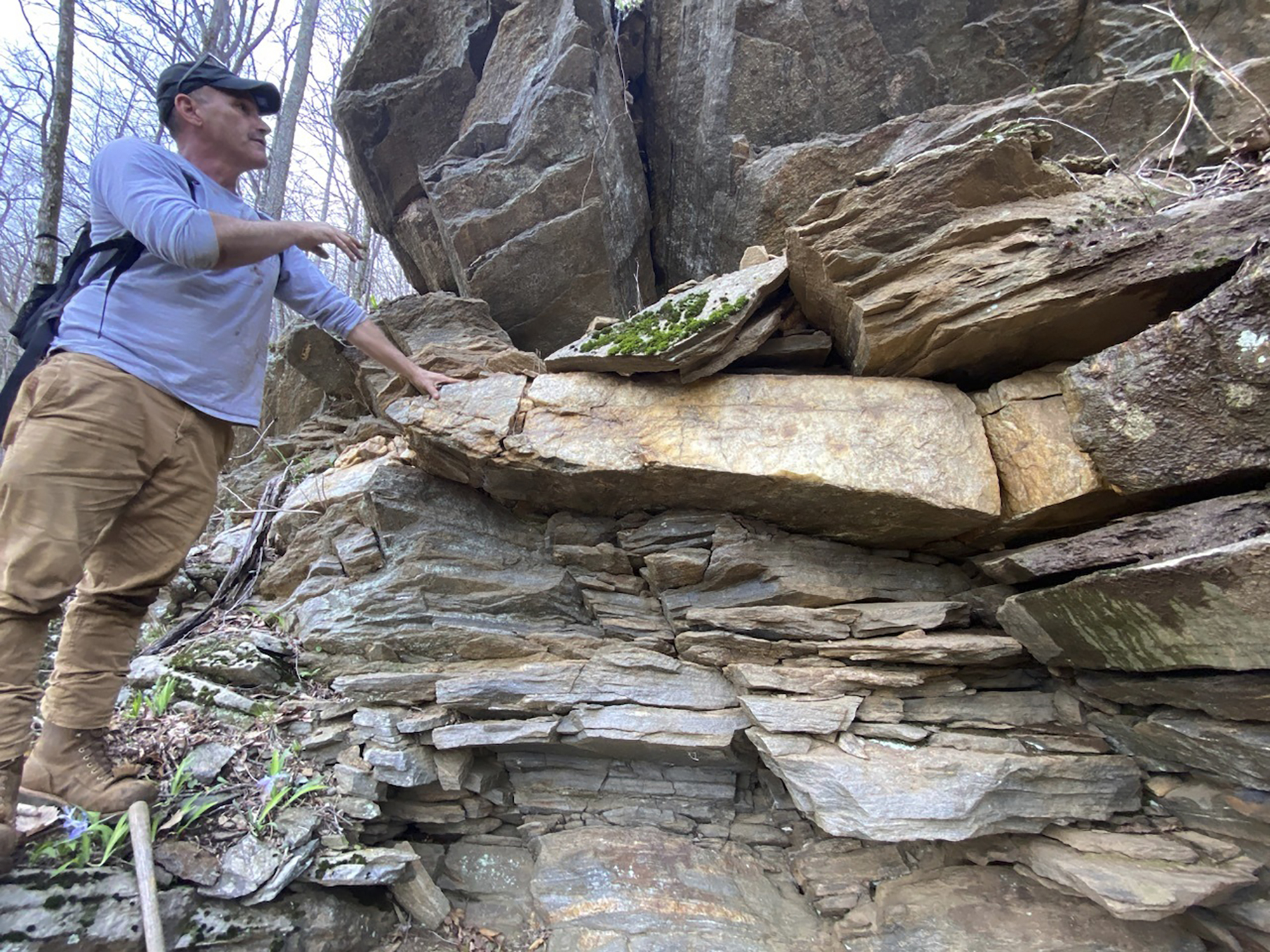 This April 16, 2024, photo provided by Philip LaPorta shows Scott Ashcraft, an archaeologist and heritage resources program manager for the Pisgah National Forest, examining a quartz vein at a prehistoric quarry site near Asheville, North Carolina. (Philip LaPorta via AP)