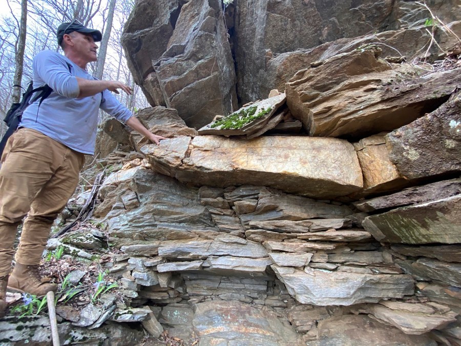 This April 16, 2024, photo provided by Philip LaPorta shows Scott Ashcraft, an archaeologist and heritage resources program manager for the Pisgah National Forest, examining a quartz vein at a prehistoric quarry site near Asheville, North Carolina. (Philip LaPorta via AP)