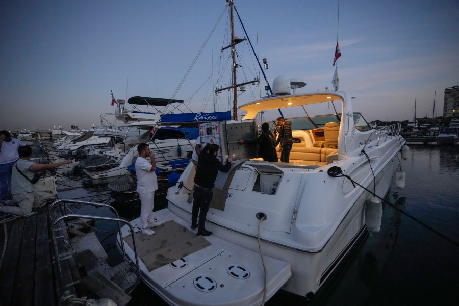 Workers carry a crate containing Sara the lion cub in preparation at the Dbayeh sea port, north of Beirut, Lebanon, Thursday, Nov. 14, 2024. (AP Photo/Hassan Ammar)