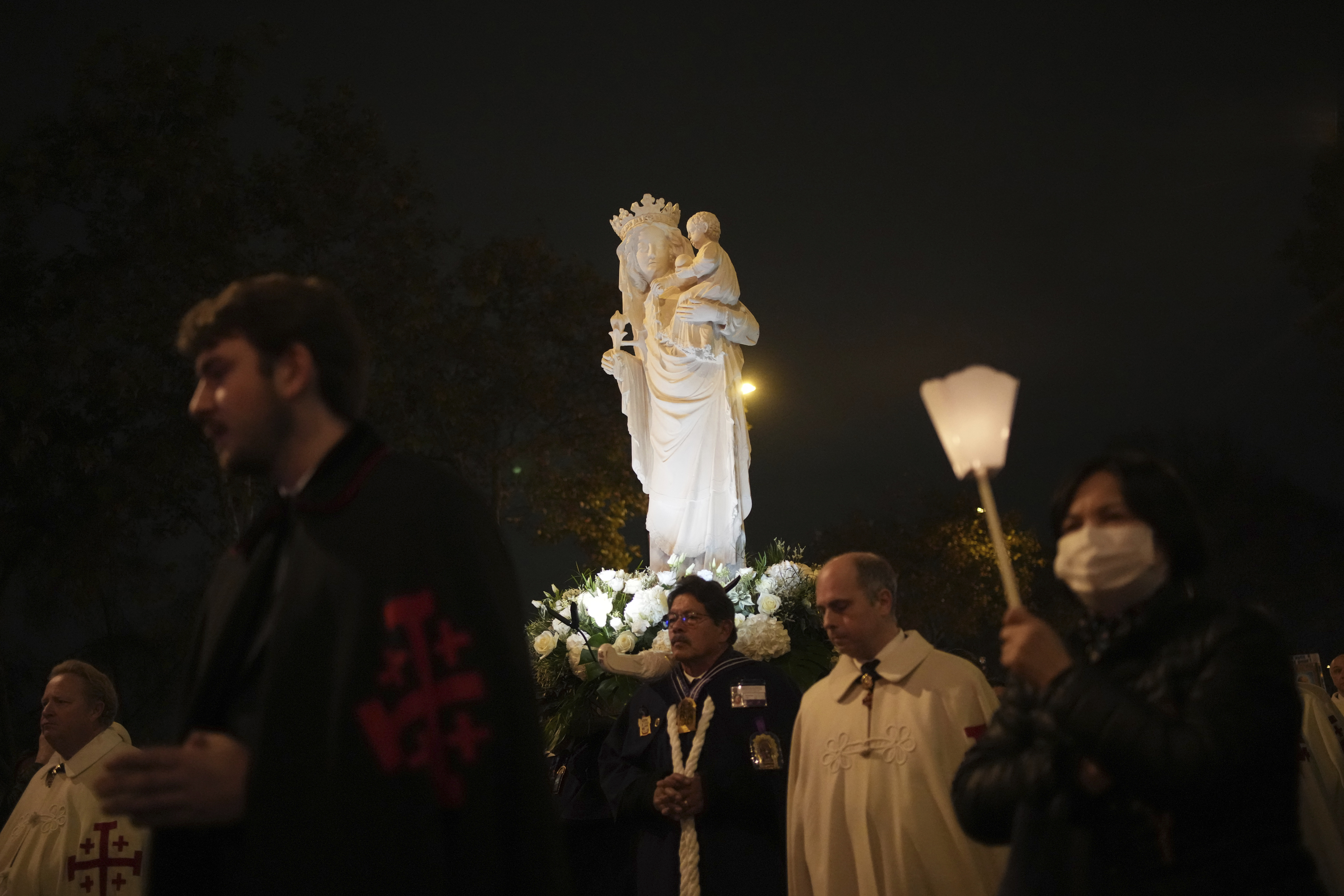 A replica of the Virgin Mary statue is carried from Saint-Germain l'Auxerrois church to Notre-Dame cathedral during a procession, Friday, Nov. 15, 2024 in Paris. (AP Photo/Christophe Ena)