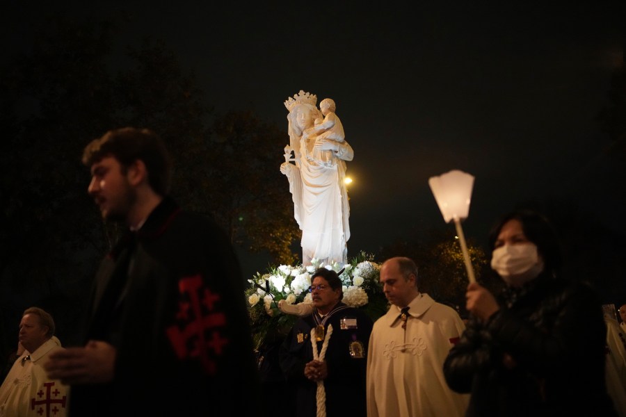 A replica of the Virgin Mary statue is carried from Saint-Germain l'Auxerrois church to Notre-Dame cathedral during a procession, Friday, Nov. 15, 2024 in Paris. (AP Photo/Christophe Ena)