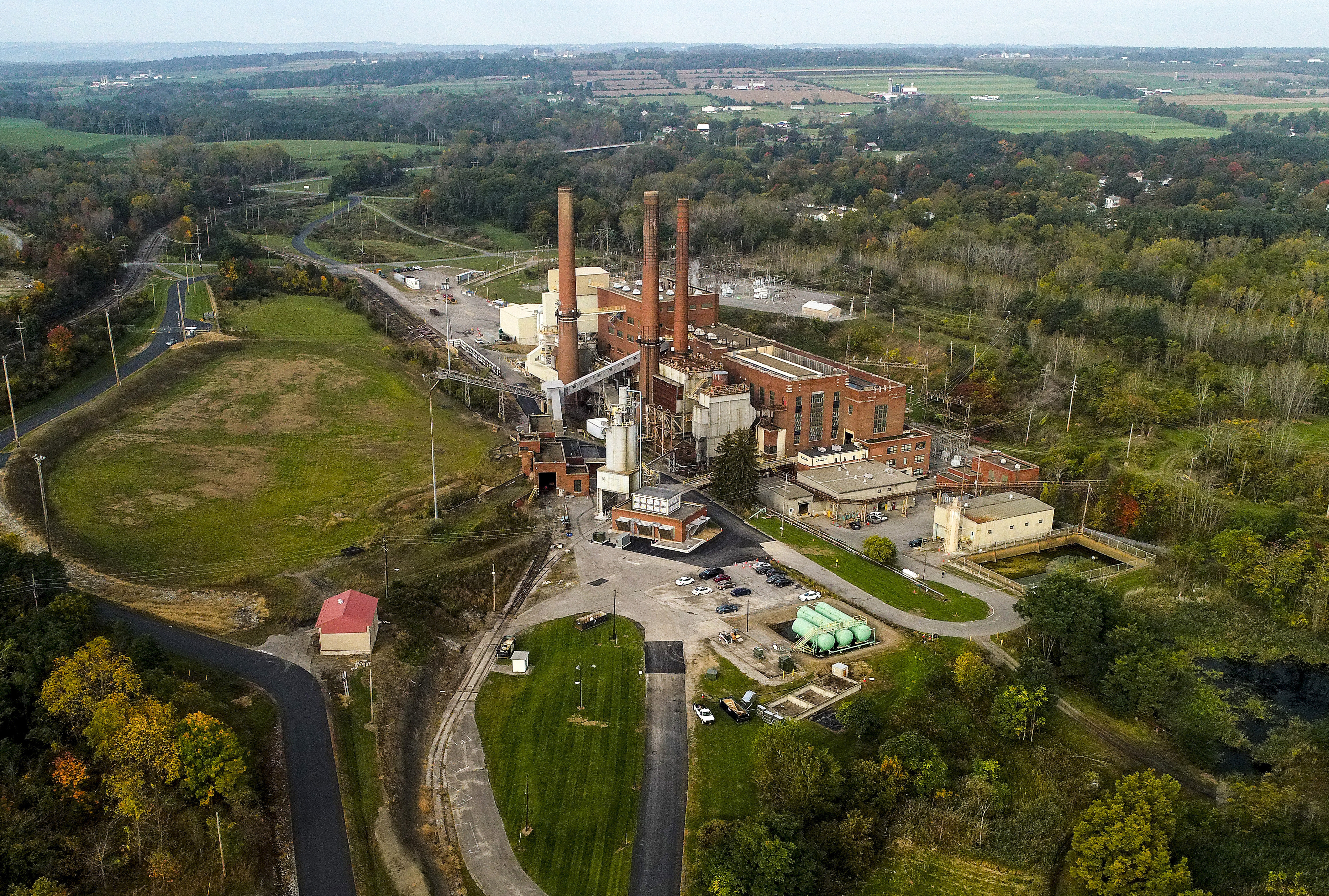 FILE - A brief patch of early morning sunlight brightens the landscape around the Greenidge Generation power plant, Oct. 15, 2021, in Dresden, N.Y. (AP Photo/Julie Jacobson, File)