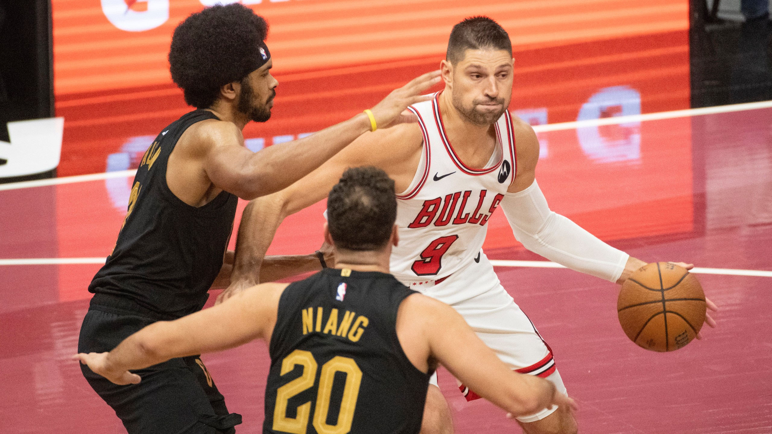 Chicago Bulls' Nikola Vucevic (9) is defended by Cleveland Cavaliers' Jarrett Allen, left, and Georges Niang (20) during the first half of an Emirates NBA cup basketball game in Cleveland, Friday, Nov 15, 2024. (AP Photo/Phil Long)