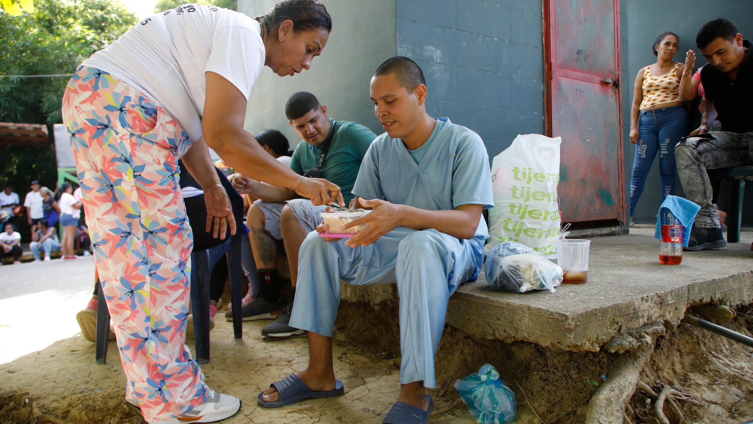 Jesus Salazar, detained during a government crackdown following anti-government protests against the results of the presidential election, receives a meal upon his release from the Yare 3 prison, in San Francisco de Yare, Venezuela, Saturday, Nov. 16, 2024. (AP Photo/Cristian Hernandez)