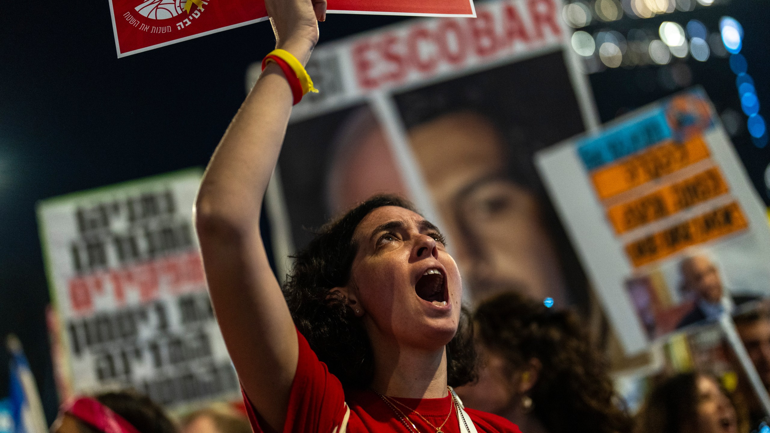 A woman shouts slogans during a protest against Prime Minister Benjamin Netanyahu's government and call for the release of hostages held in the Gaza Strip by the Hamas militant group, in Tel Aviv, Israel, Saturday, Nov. 16, 2024. (AP Photo/Francisco Seco)