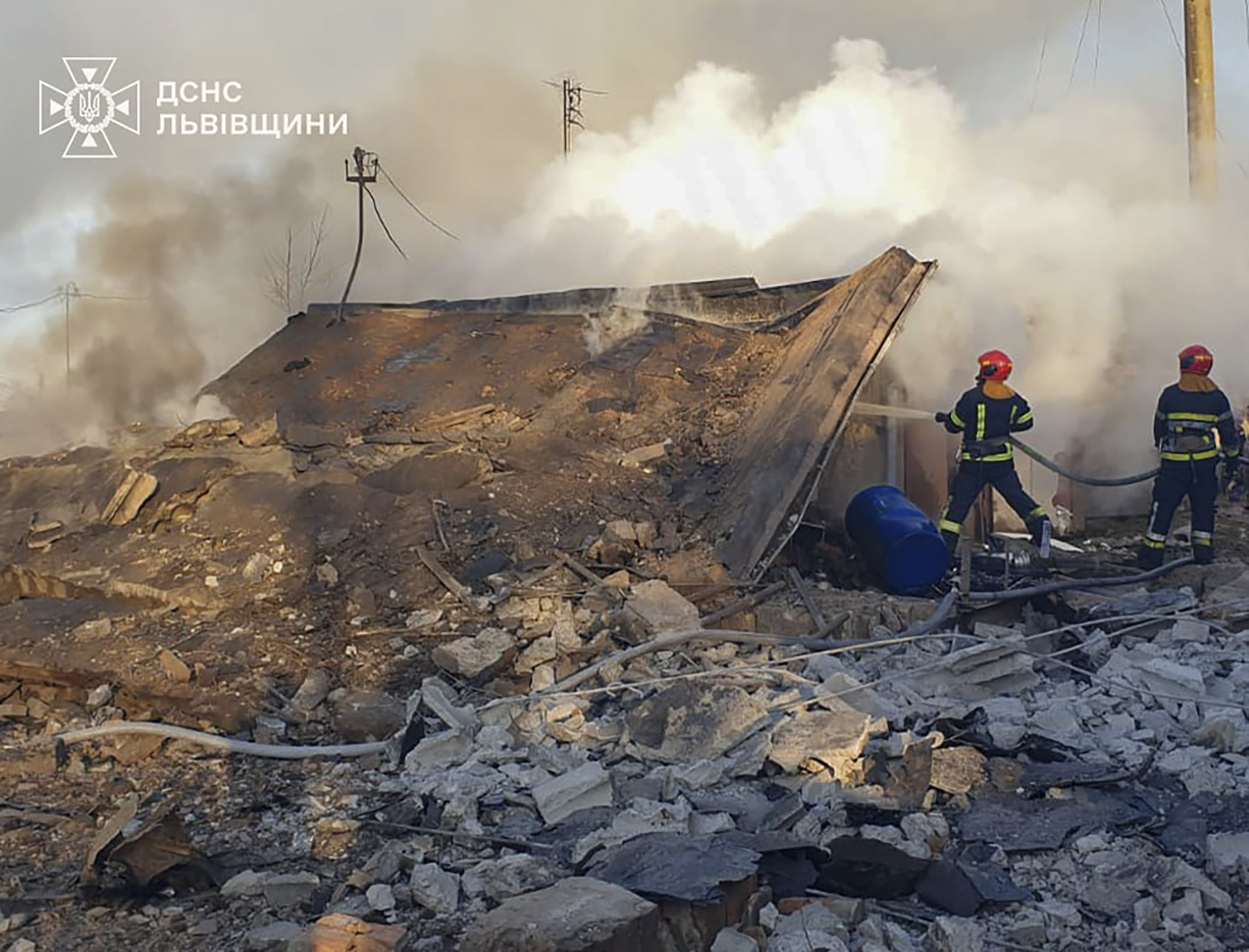 In this photo provided by the Ukrainian Emergency Service, emergency services personnel work to extinguish a fire following a Russian rocket attack in Lviv, Ukraine, Sunday, Nov. 17, 2024. (Ukrainian Emergency Service via AP)