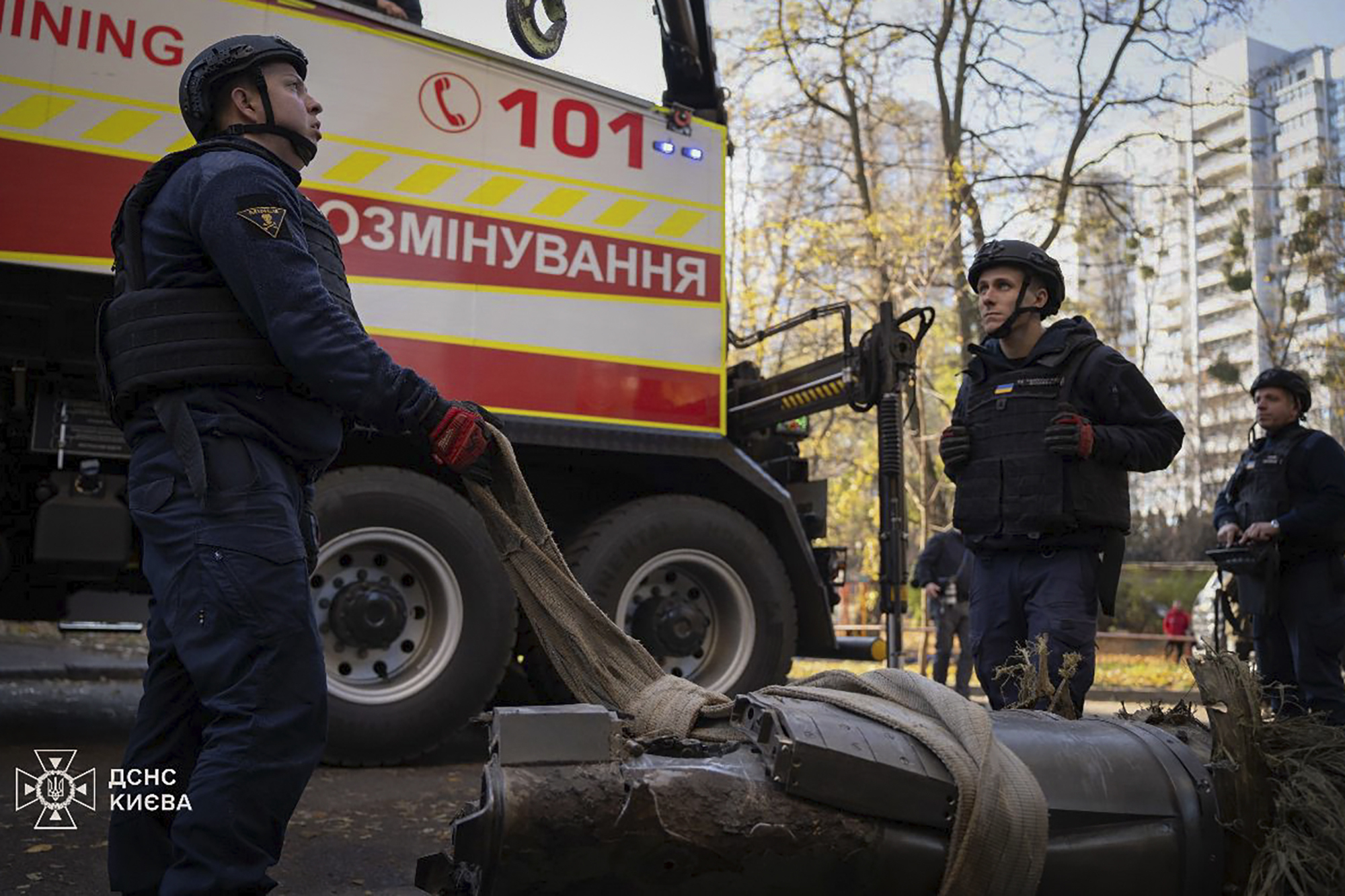 In this photo provided by the Ukrainian Emergency Service, emergency services personnel remove part of a Russian missile that hit an apartment house during massive missile attack in Kyiv, Ukraine, Sunday, Nov. 17, 2024. (Ukrainian Emergency Service via AP)