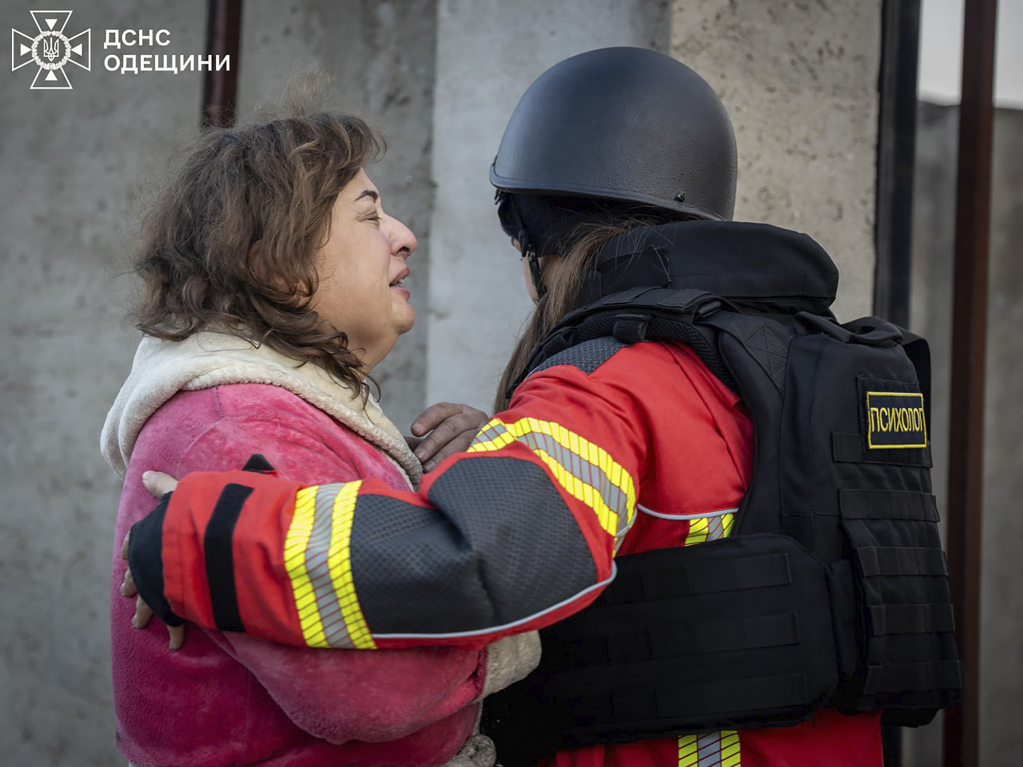 In this photo provided by the Ukrainian Emergency Service, a psychologist calms down a woman who lost her home in Russian missile attack in Odesa region, Ukraine, Sunday, Nov. 17, 2024. (Ukrainian Emergency Service via AP)