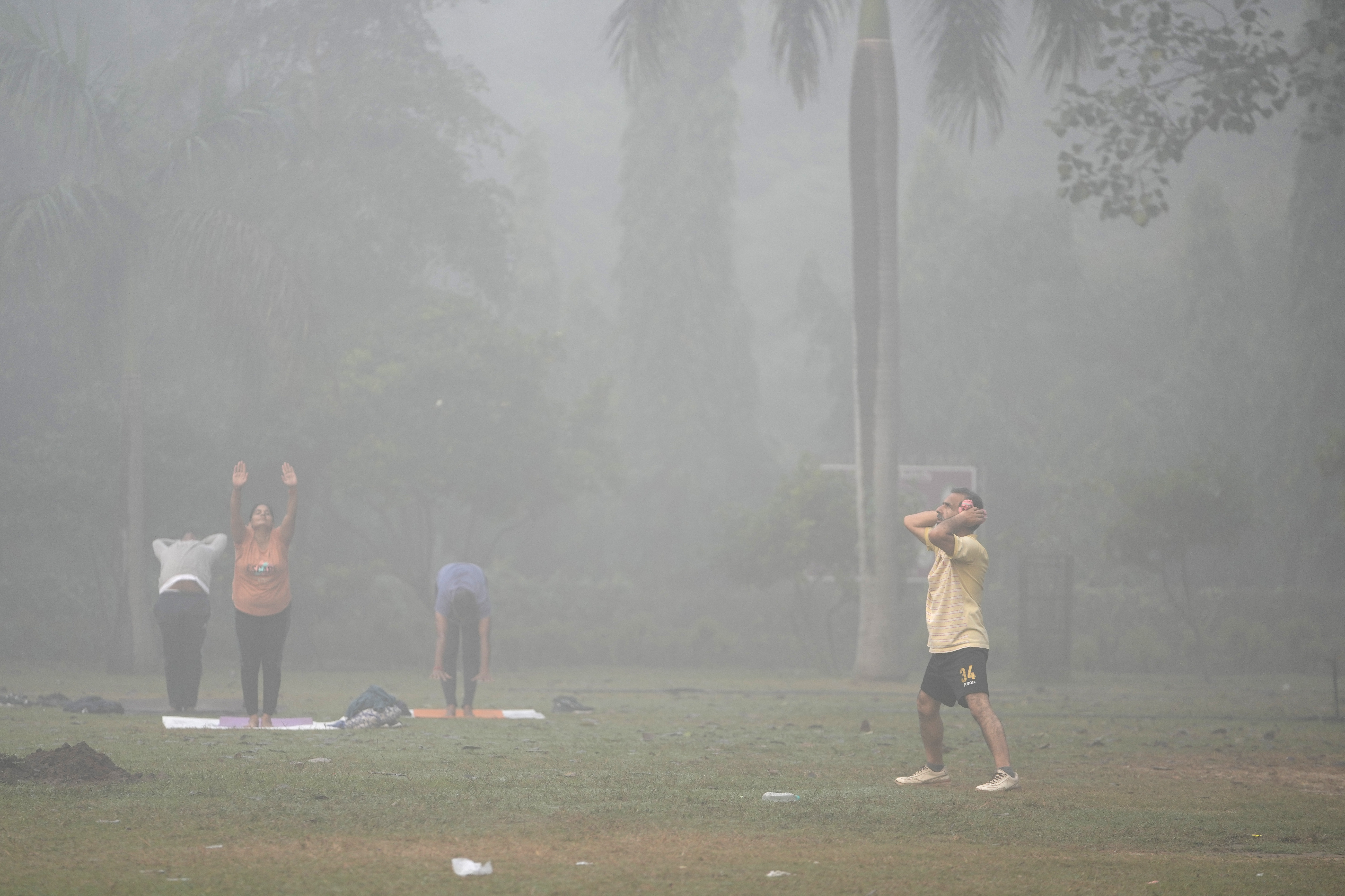 Bashir Ahmad Mir performs morning exercises surrounded by smog in Lodhi Gardens in New Delhi, India, Friday, Nov. 15, 2024. (AP Photo/Manish Swarup)