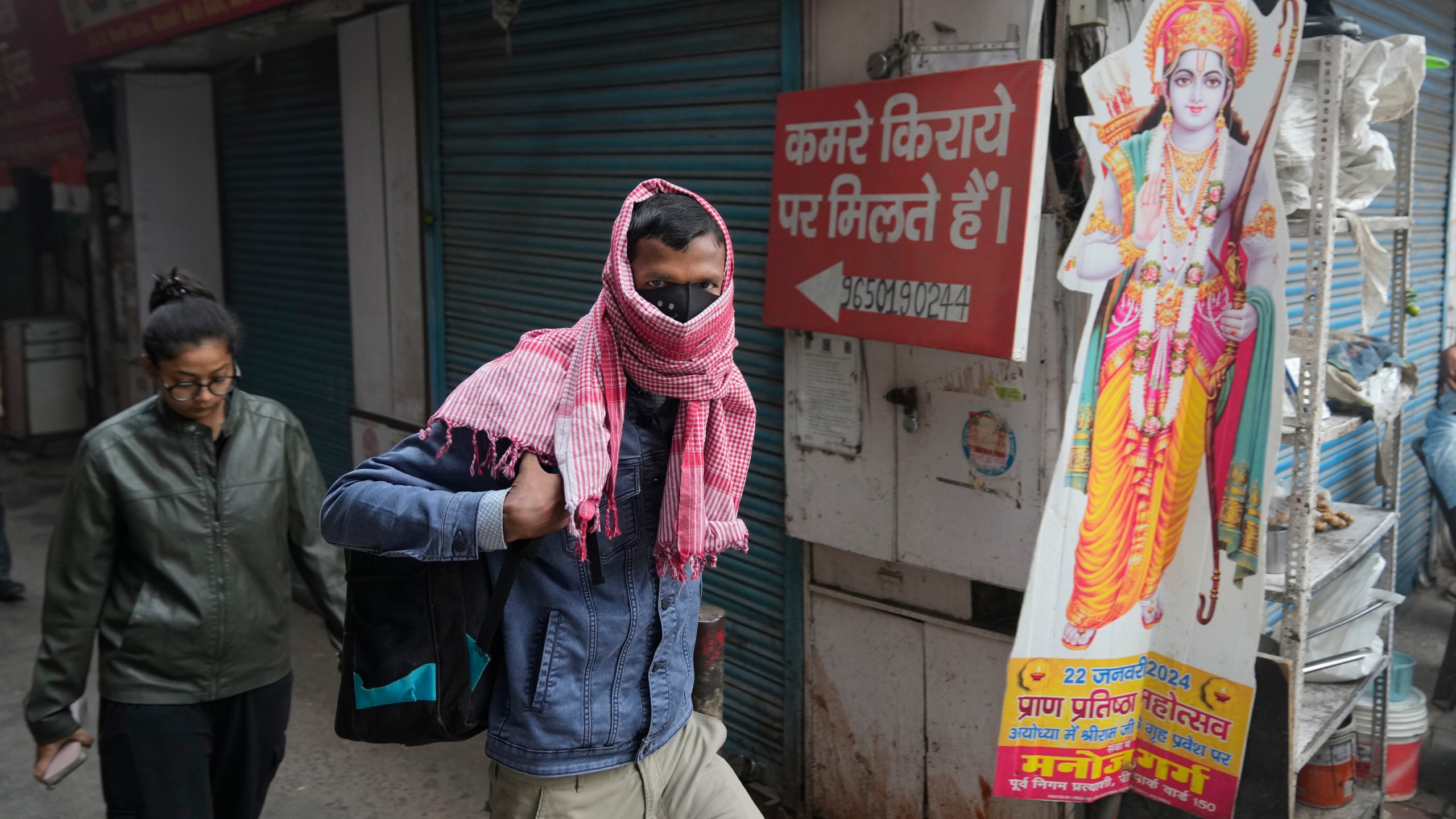 A office goer walks wearing a face mask amidst a thick layer of smog as air pollution shoots up in New Delhi, India, Monday, Nov. 18, 2024. (AP Photo/Manish Swarup)