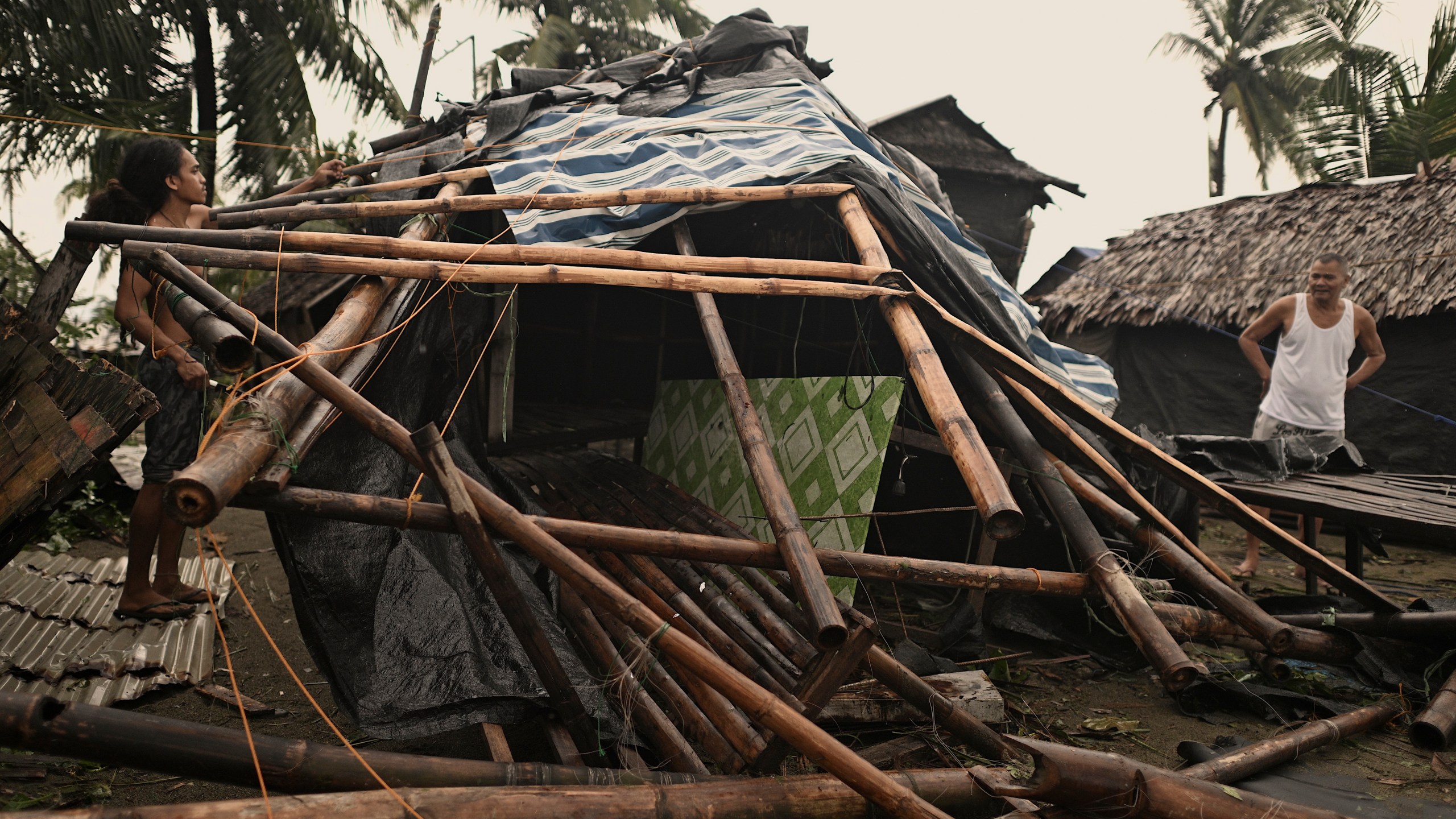 A resident checks his damaged home that was blown off by strong winds caused by Typhoon Man-yi in the municipality of Baler, Aurora province, northeastern Philippines Monday, Nov. 18, 2024. (AP Photo/Noel Celis)