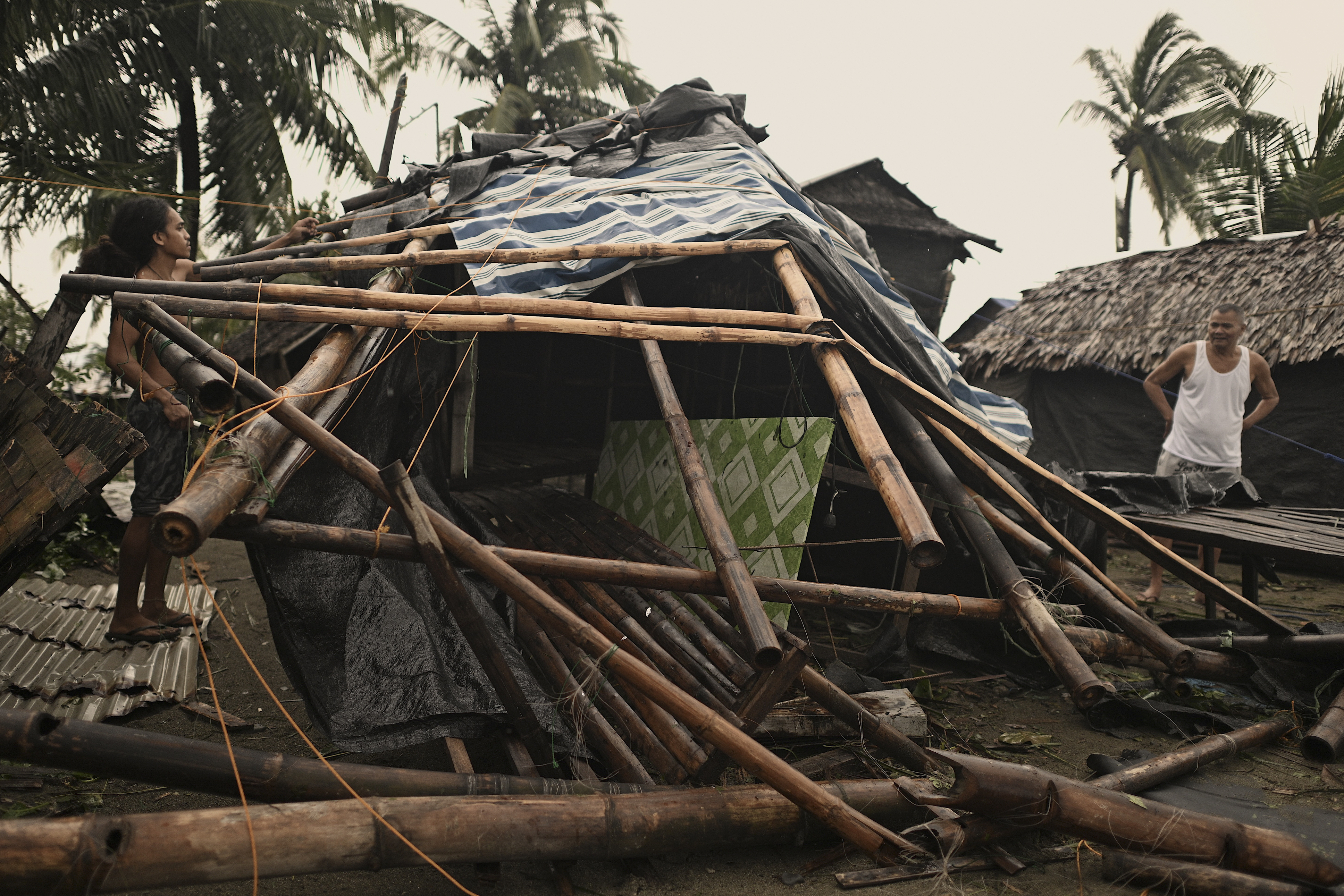 A resident checks his damaged home that was blown off by strong winds caused by Typhoon Man-yi in the municipality of Baler, Aurora province, northeastern Philippines Monday, Nov. 18, 2024. (AP Photo/Noel Celis)