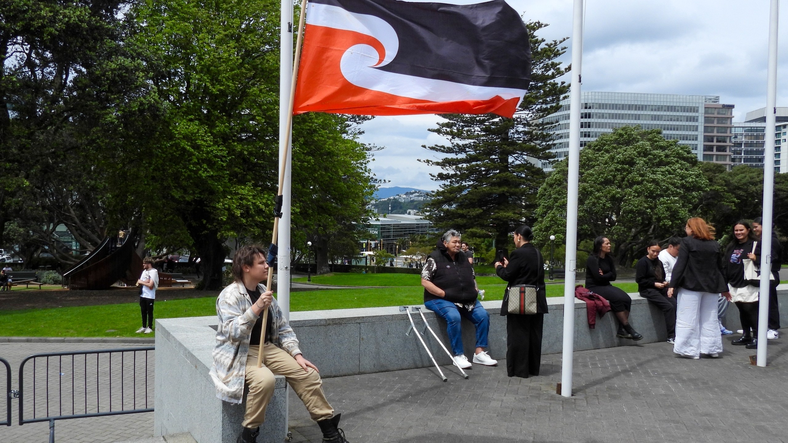 FILE - A protester against the Treaty Principles Bill sits outside Parliament in Wellington, New Zealand, Thursday, Nov. 14, 2024. (AP Photo/Charlotte Graham-McLay, File)