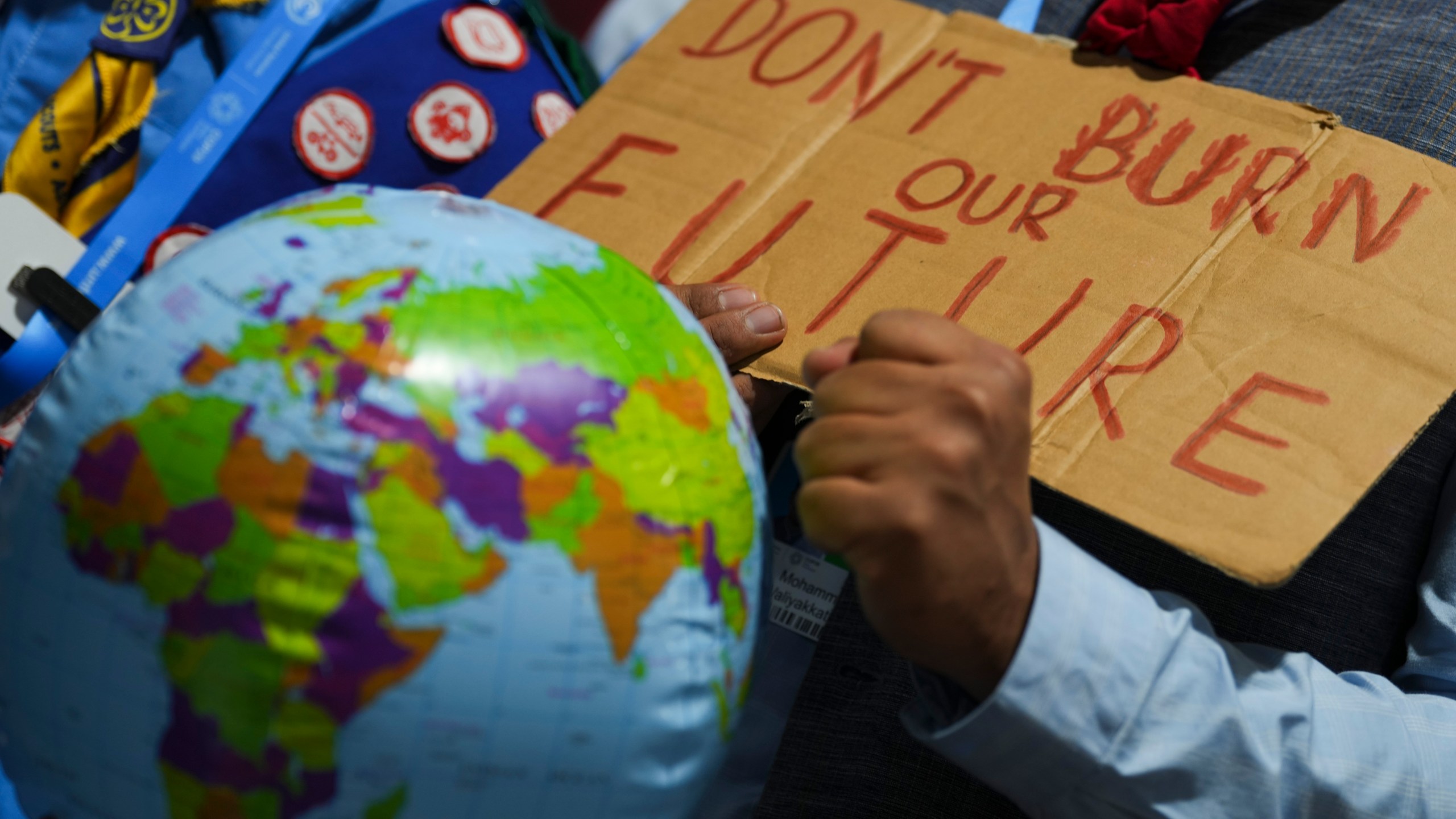 A demonstrators holds a sign that reads "don't burn our future" at the COP29 U.N. Climate Summit, Monday, Nov. 18, 2024, in Baku, Azerbaijan. (AP Photo/Peter Dejong)