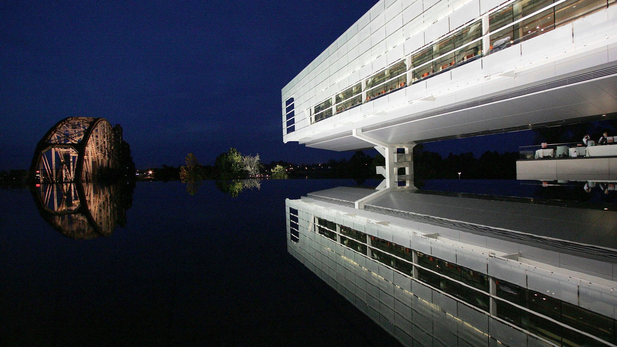 FILE - Lights reflect off a railroad bridge on the grounds of Bill Clinton's presidential library as the lighted center is reflected in a fountain, Nov. 17, 2004, in Little, Rock, Ark., the night before the grand opening. (AP Photo/Ric Feld, File)